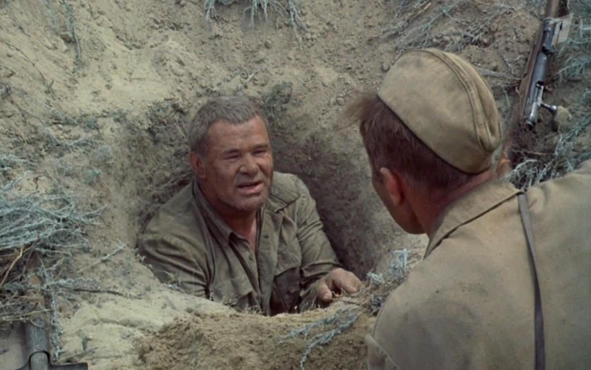 Ein Soldat im Schützengraben spricht mit einem anderen Soldaten draußen.