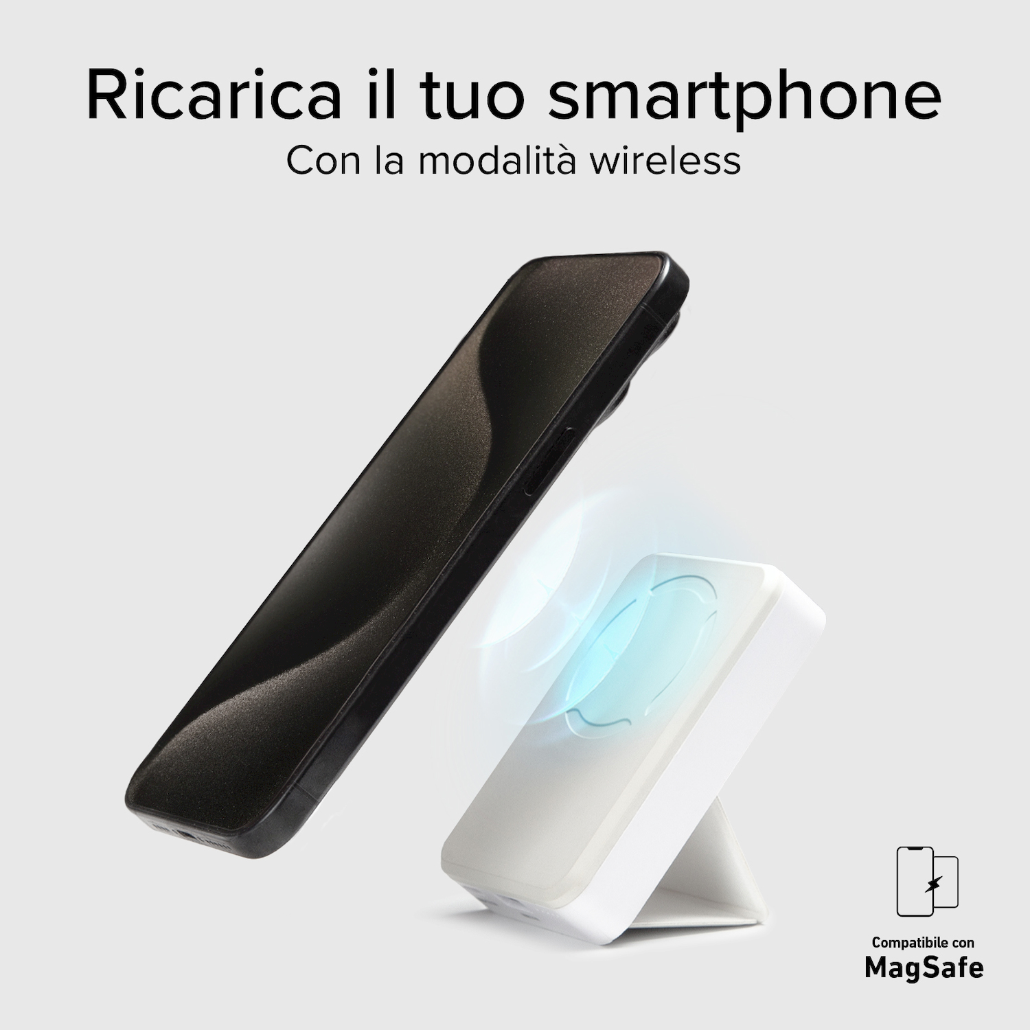Uno smartphone si ricarica wireless su un caricabatterie bianco MagSafe su sfondo grigio.