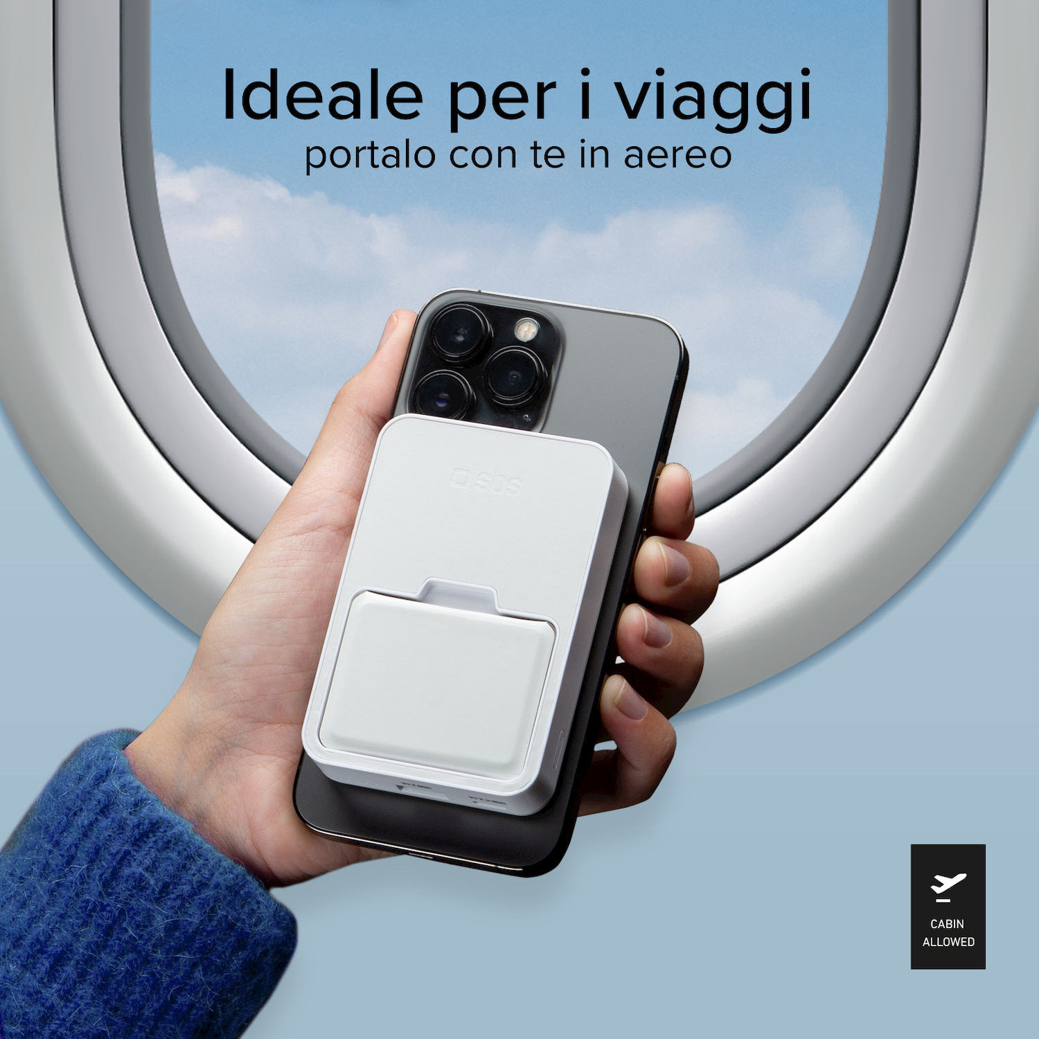 Mano tiene smartphone con power bank bianco davanti a oblò aereo.