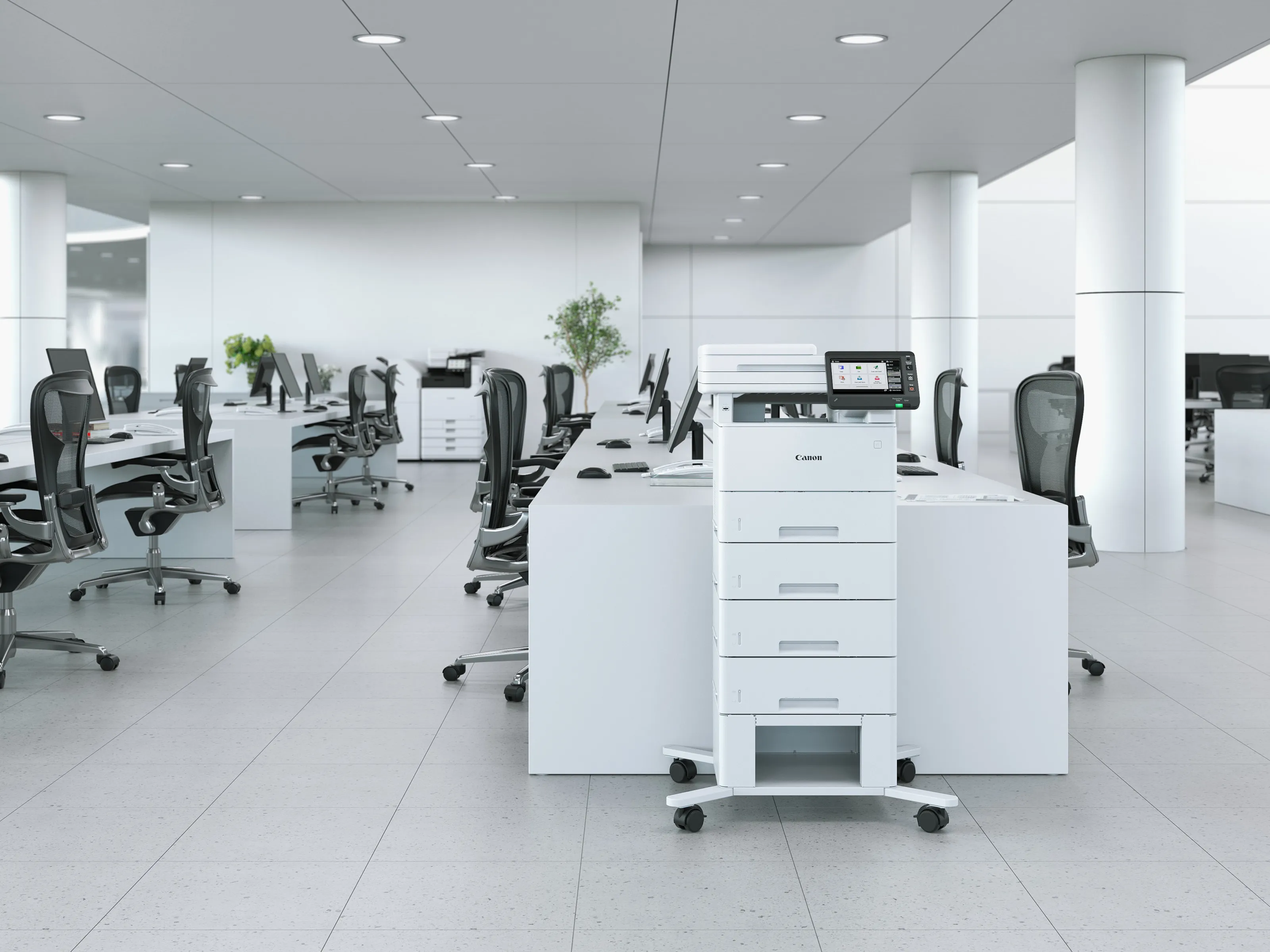 Moderne Büro-Innenansicht mit weißen Schreibtischen, schwarzen Stühlen und einem großen Canon-Drucker im Vordergrund.
