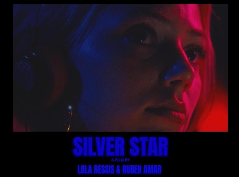 Nahaufnahme einer jungen Frau mit Kopfhörern, beleuchtet in Neonblau und Rot, darunter der Filmtitel Silver Star.