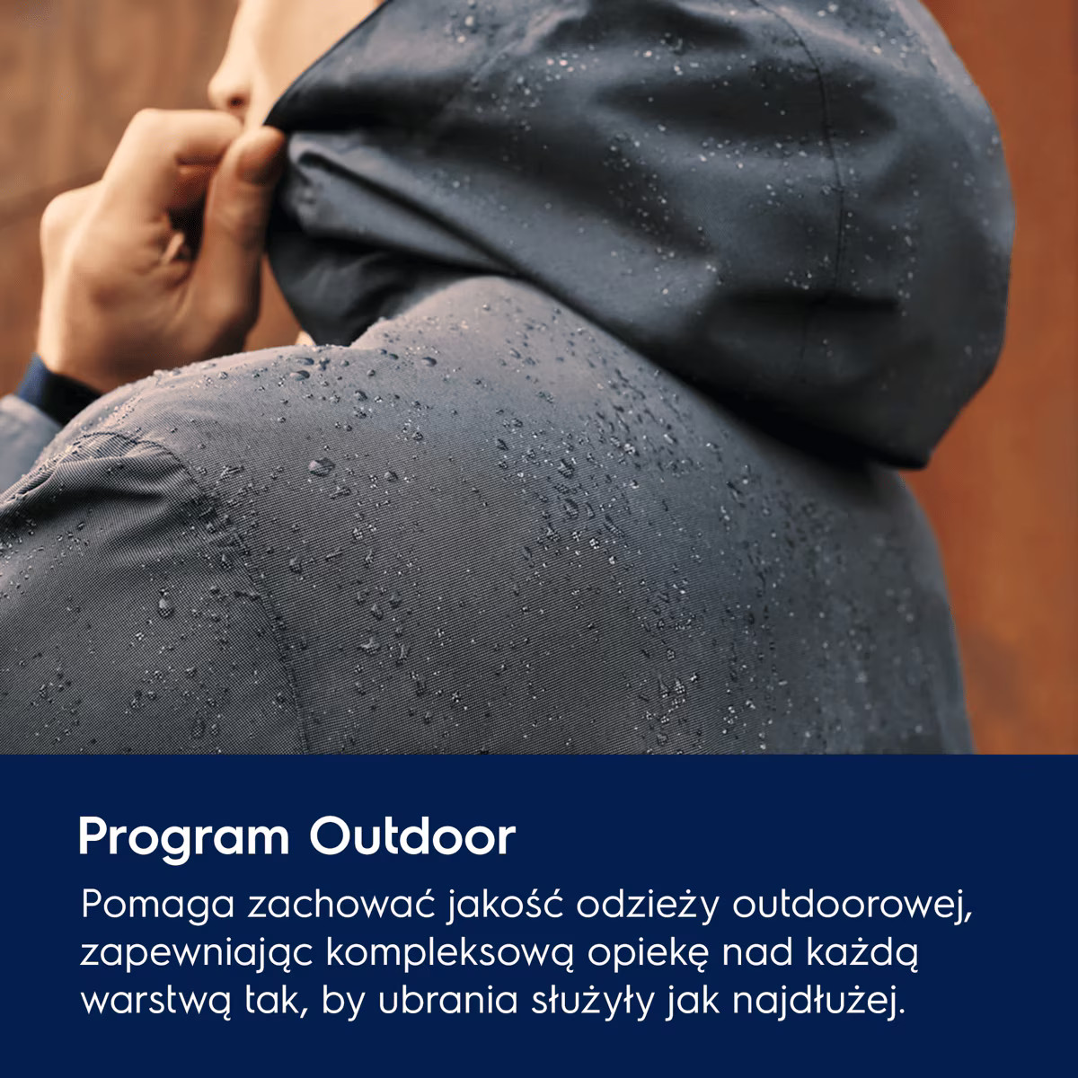 Osoba w ciemnej, wodoodpornej kurtce pokrytej kroplami deszczu reguluje kaptur na dworze.