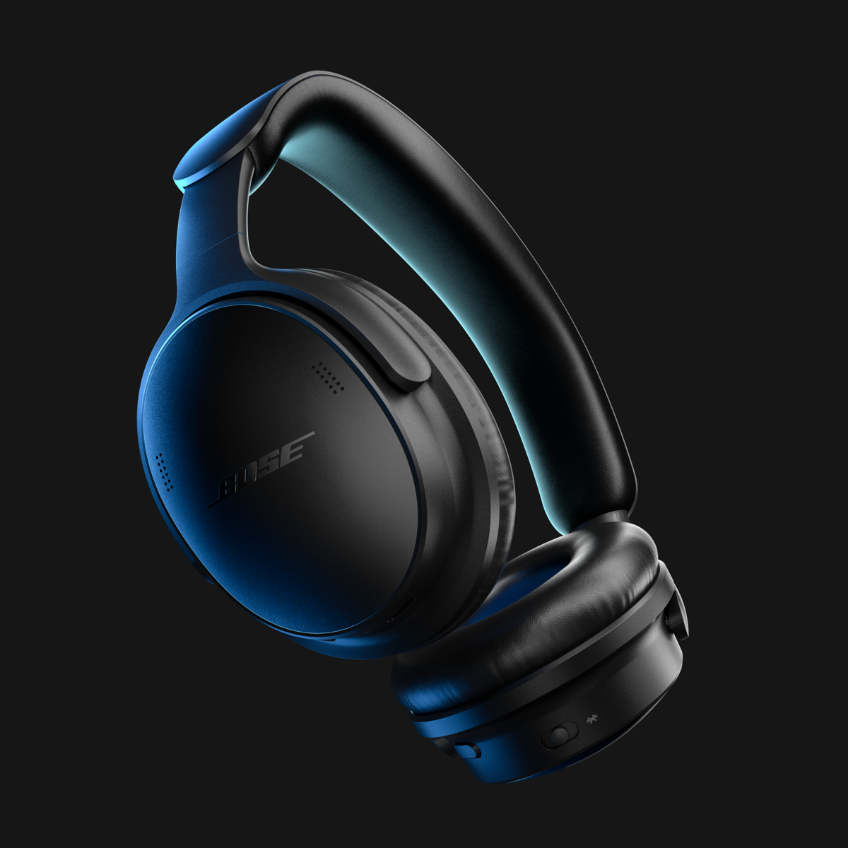 Élégants écouteurs circum-auriculaires Bose noirs éclairés d'une lumière bleue sur fond sombre.