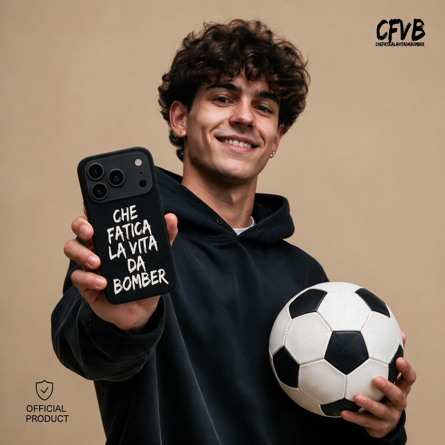 Un giovane sorridente in felpa nera tiene un pallone da calcio e una cover per telefono con scritta bianca su fondo beige.