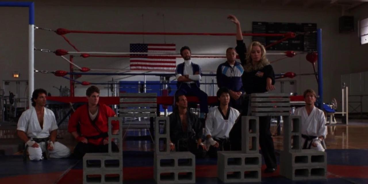 Karate-Schüler und Trainer in einer Turnhalle vor einem Boxring und einer US-Flagge.