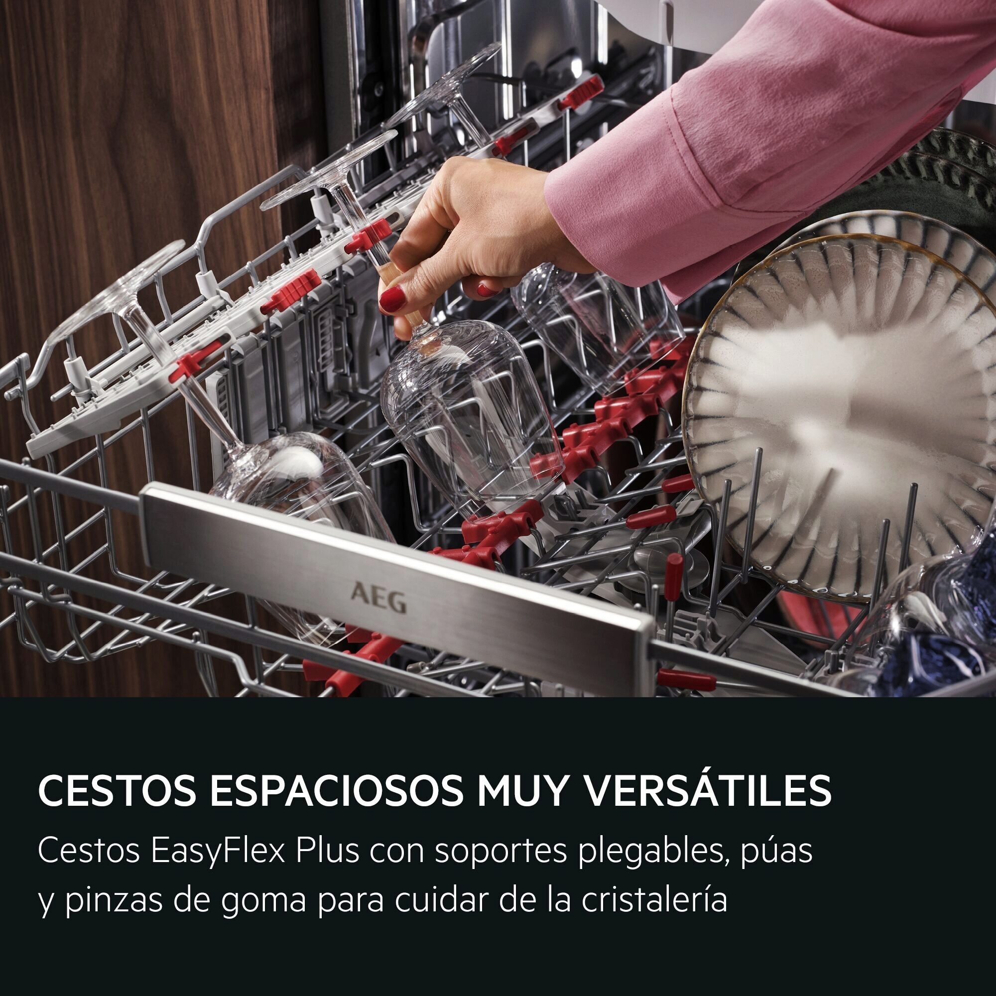 Una mano coloca copas de vino en la cesta de un lavavajillas AEG abierto.