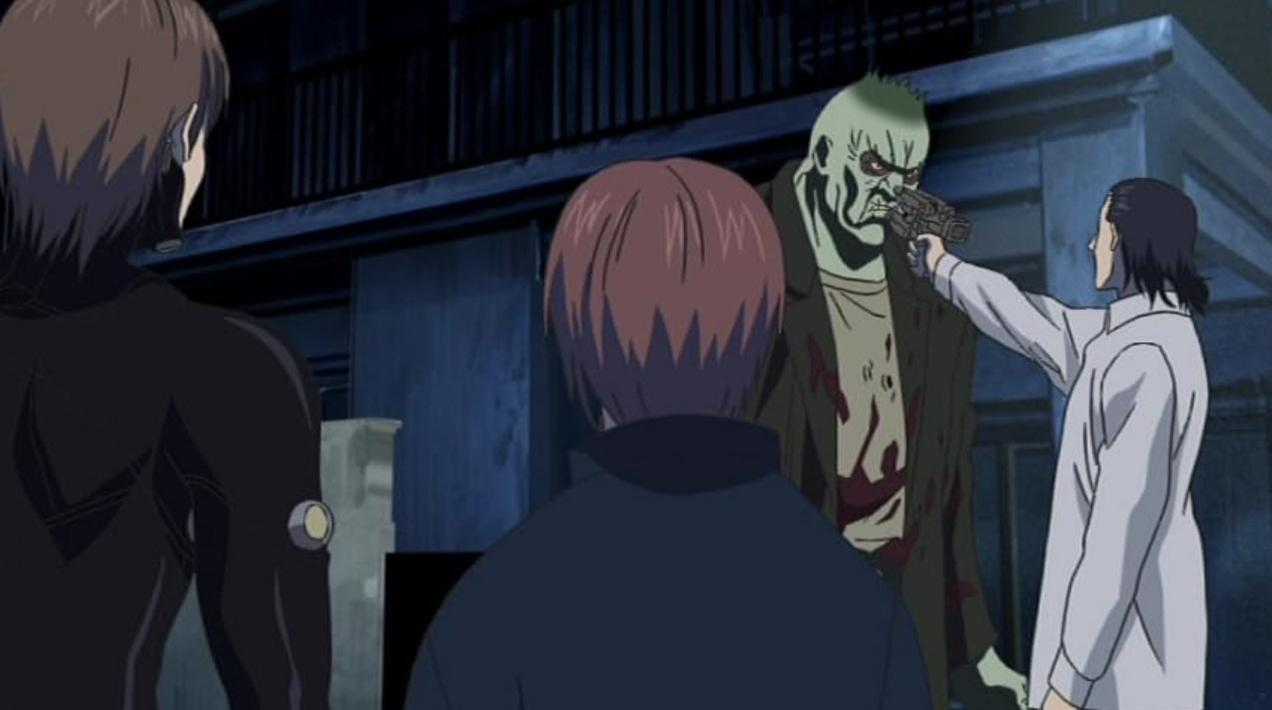 Anime-Szene, in der ein Mann mit weißem Kittel eine Pistole auf das Gesicht eines grünen Monsters richtet.