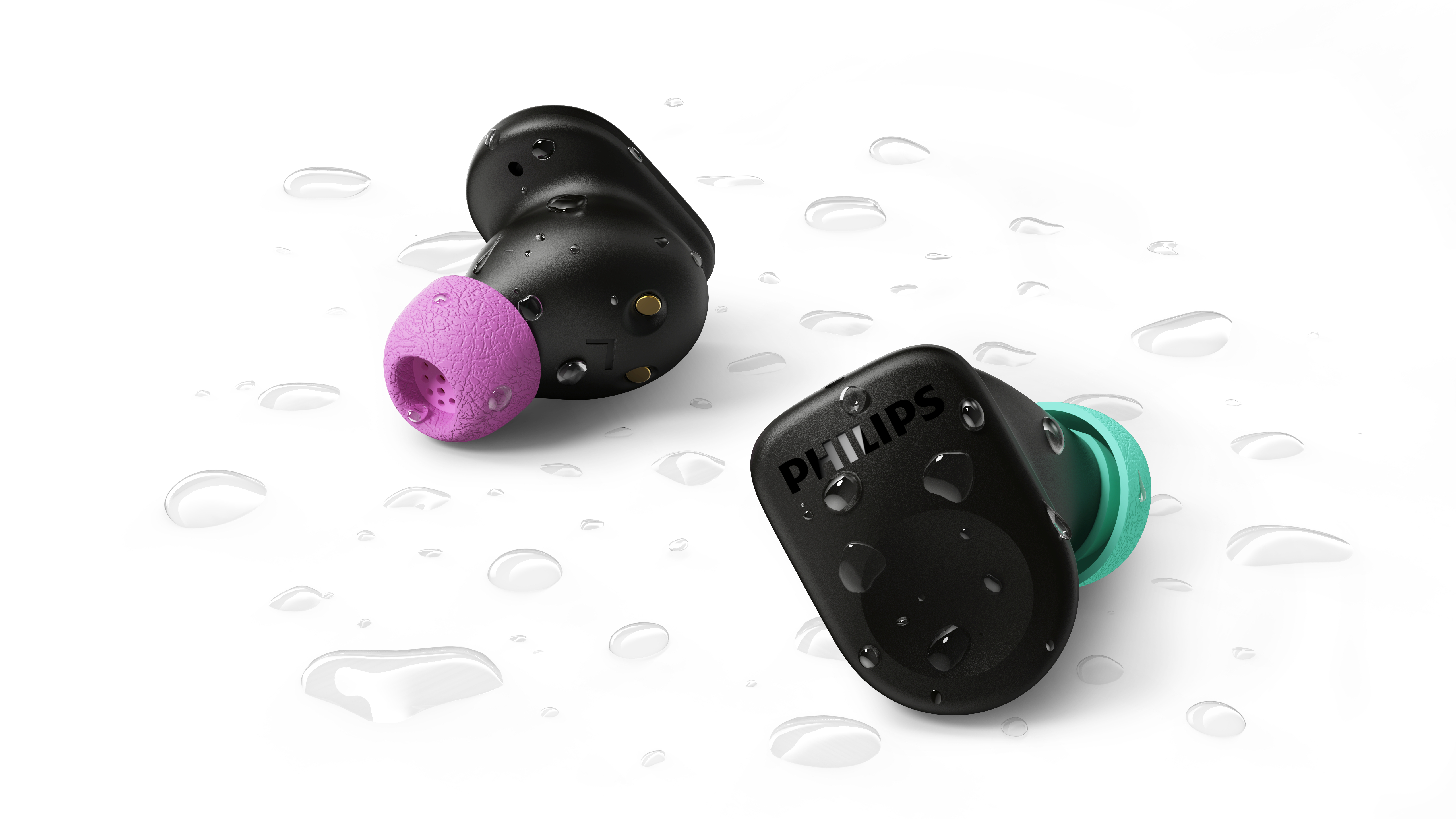 Zwei schwarze kabellose Philips Kopfhörer mit bunten Spitzen und Wassertropfen auf weißer Oberfläche.