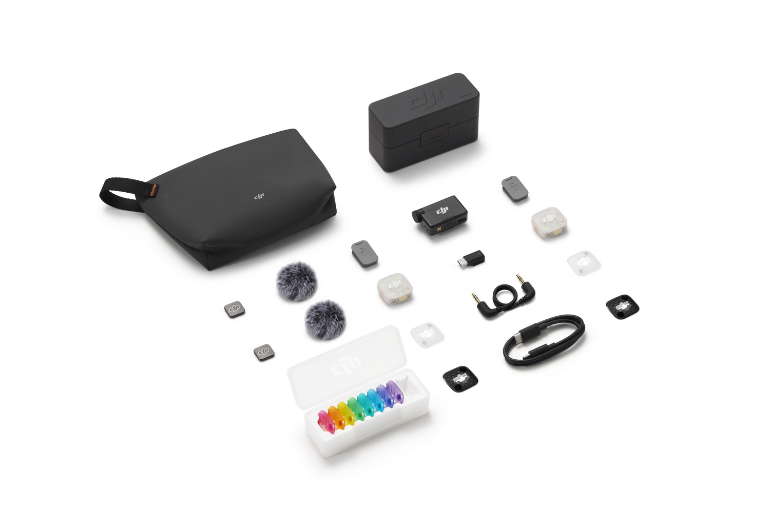 Kit de micrófono DJI con bolsa, estuche de carga, receptores, antivientos y fundas coloridas sobre fondo blanco.