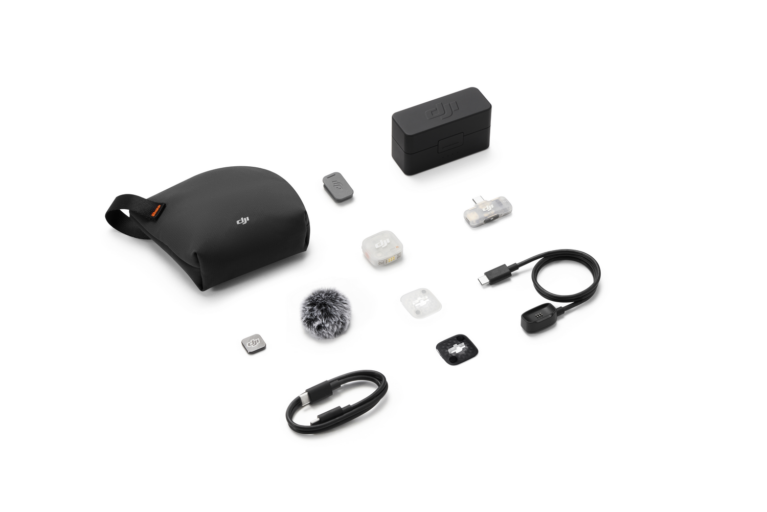 Kit de micrófono DJI con estuche, caja de carga, antiviento, transmisores, receptores y cables en fondo blanco.