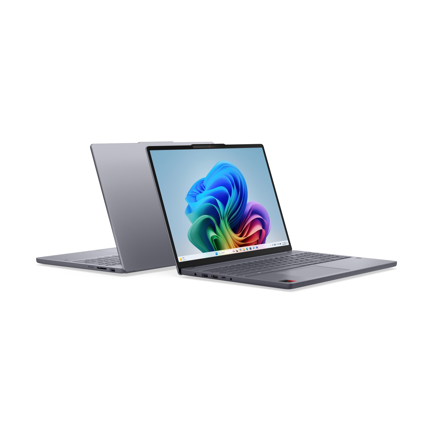 Due laptop grigi su sfondo bianco, uno frontale con onde colorate sullo schermo, l'altro leggermente dietro.