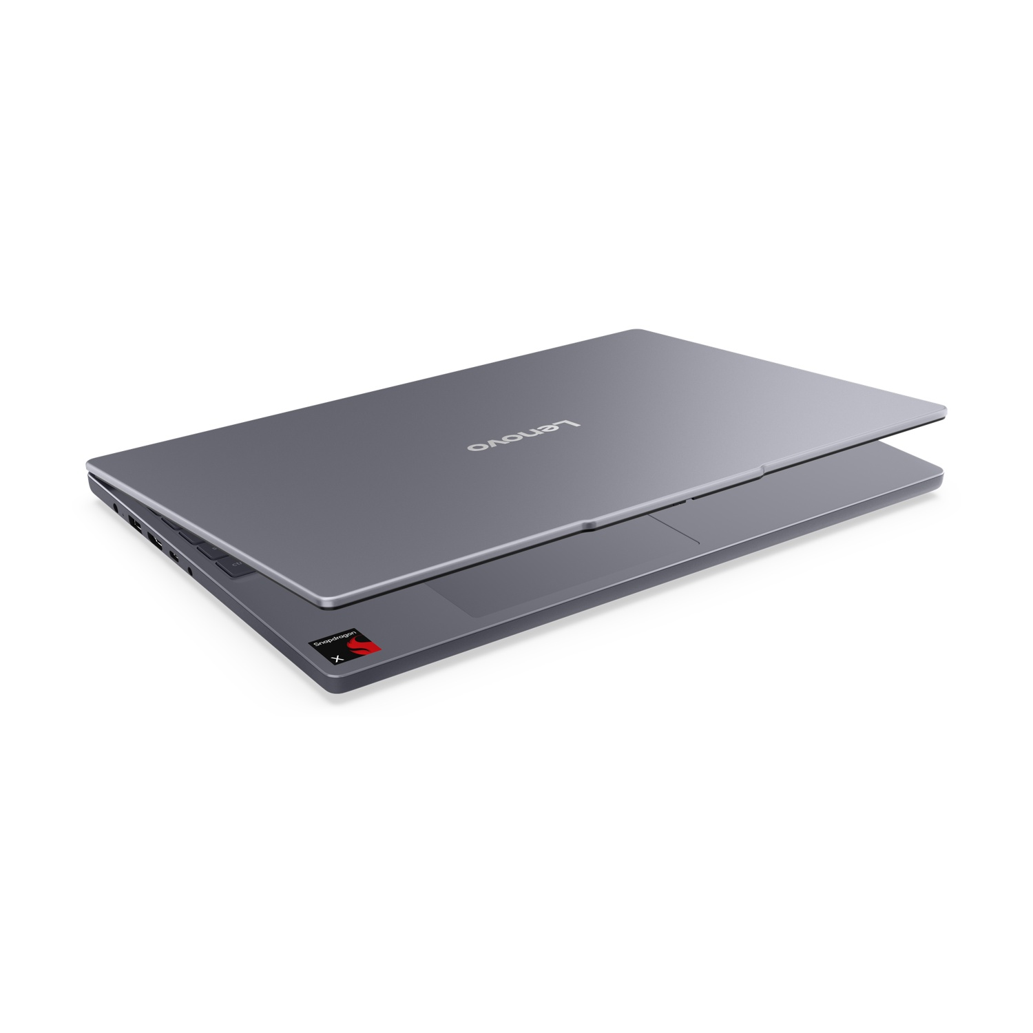 Un laptop Lenovo grigio chiuso visto dall'alto, con il logo del marchio e un adesivo Snapdragon all'interno.