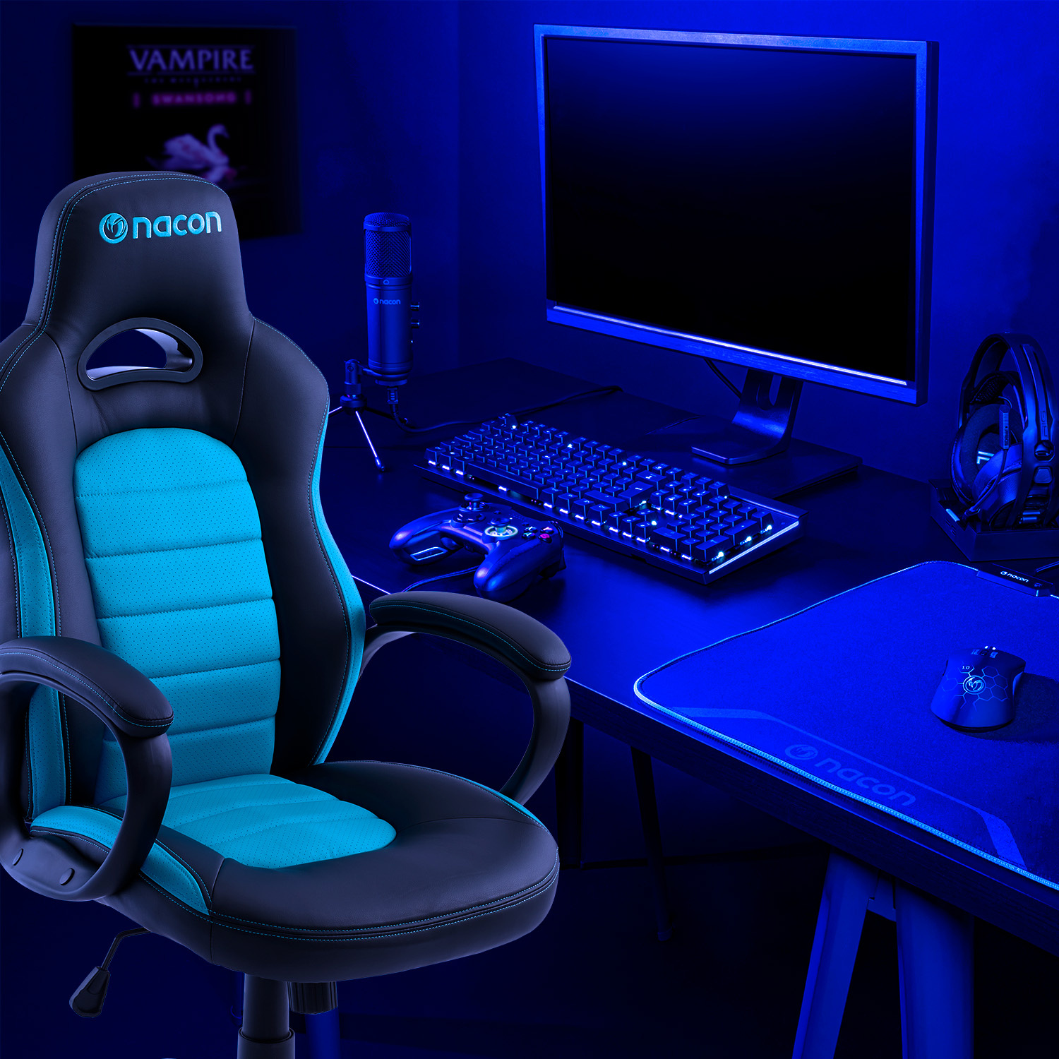 Una postazione da gioco con sedia Nacon nera e blu, scrivania, monitor, tastiera, mouse e microfono sotto luce blu.