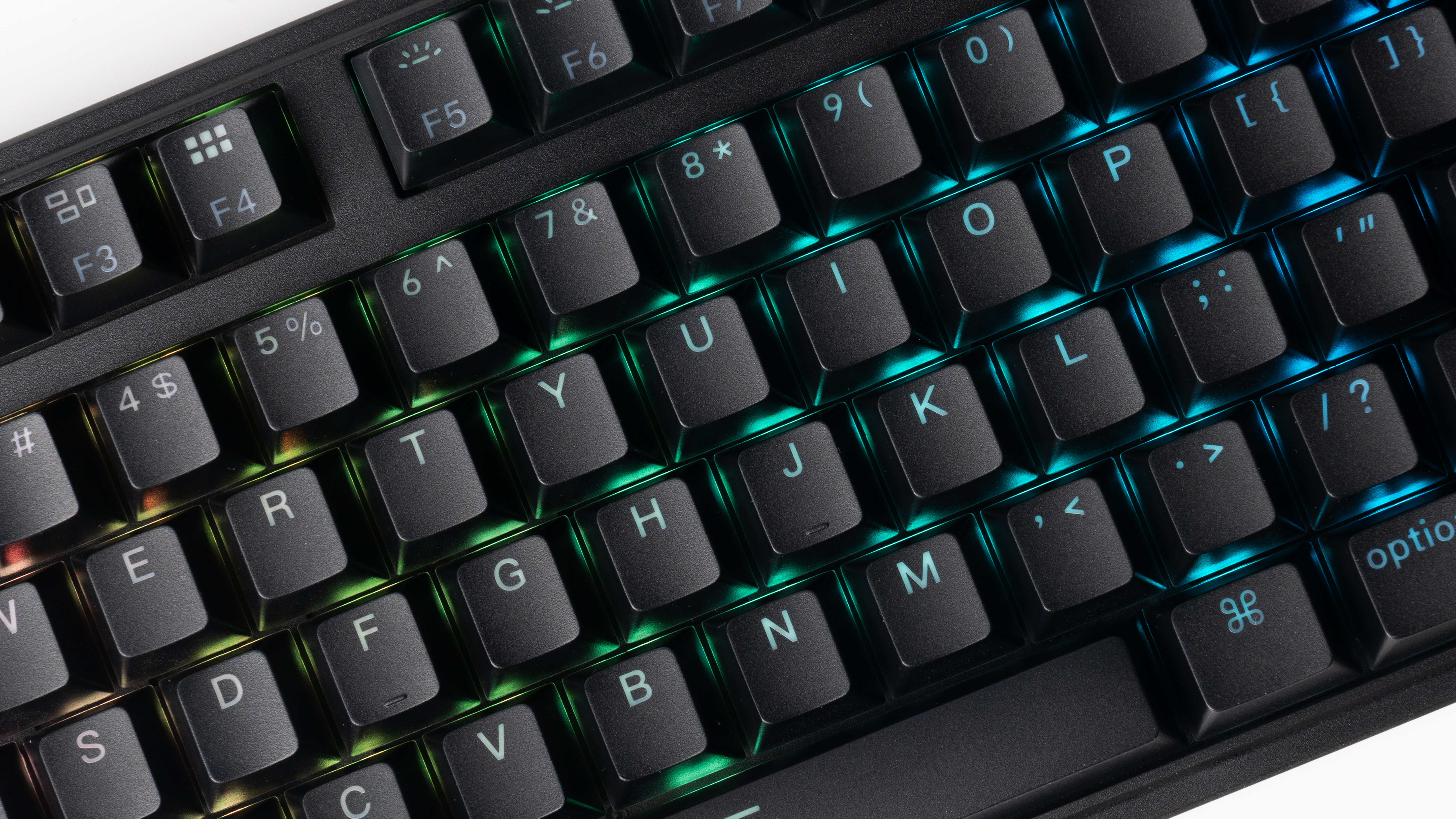 Nahaufnahme einer schwarzen Tastatur mit lebendiger grüner und blauer LED-Hintergrundbeleuchtung zwischen den Tasten.