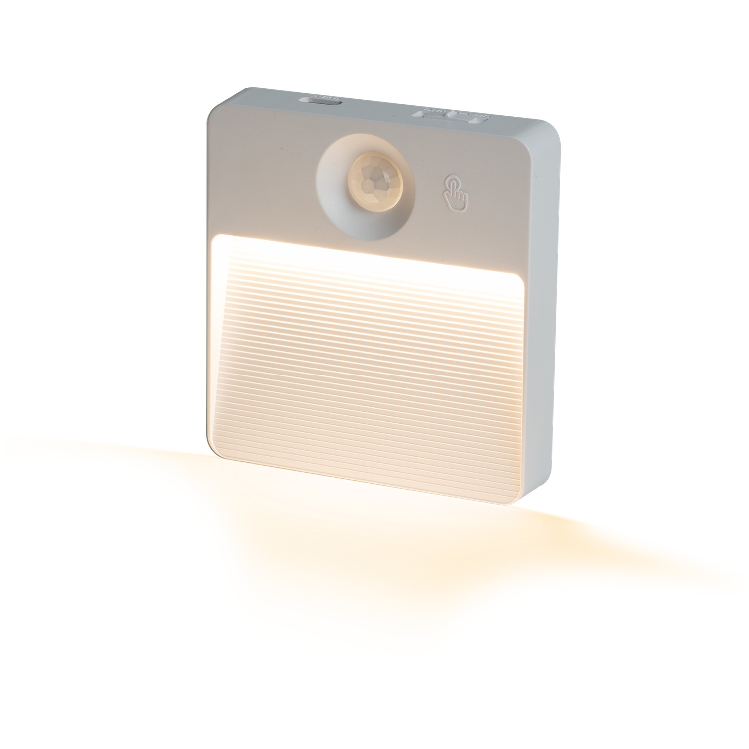 Een klein wit LED-nachtlampje met bewegingssensor en warm gloeiend licht op een witte achtergrond.