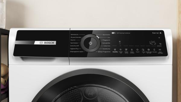 Bedienfeld einer weißen Bosch Serie 6 Waschmaschine mit schwarzem Display und Drehregler.