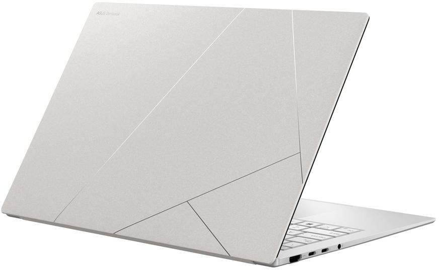 Egy ezüst színű ASUS ZenBook laptop, a zárt fedélen geometriai vonalmintával, fehér háttér előtt.