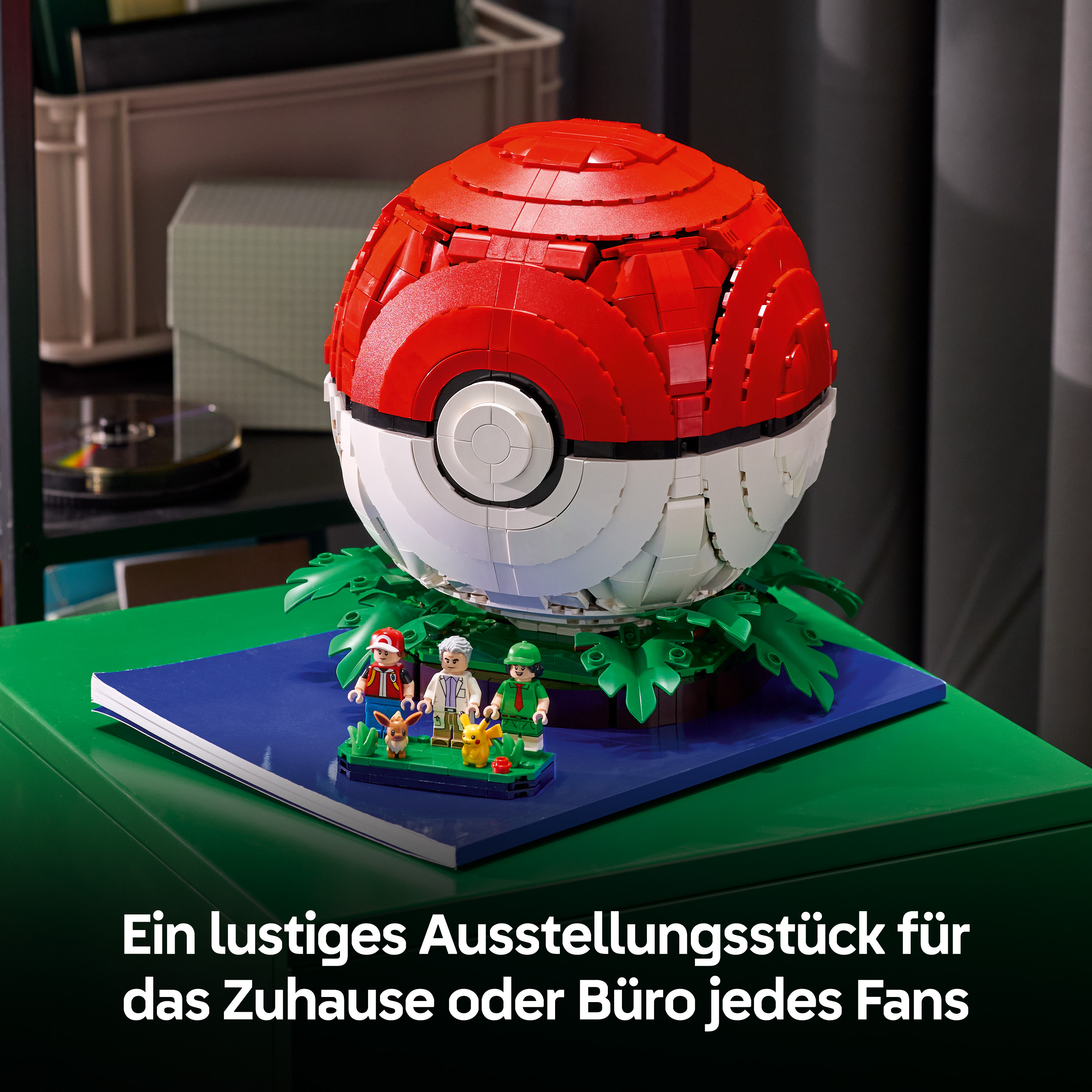 Ein großer, aus Bausteinen geBauchter Pokéball mit kleinen Figuren davor auf einem grünen Tisch.
