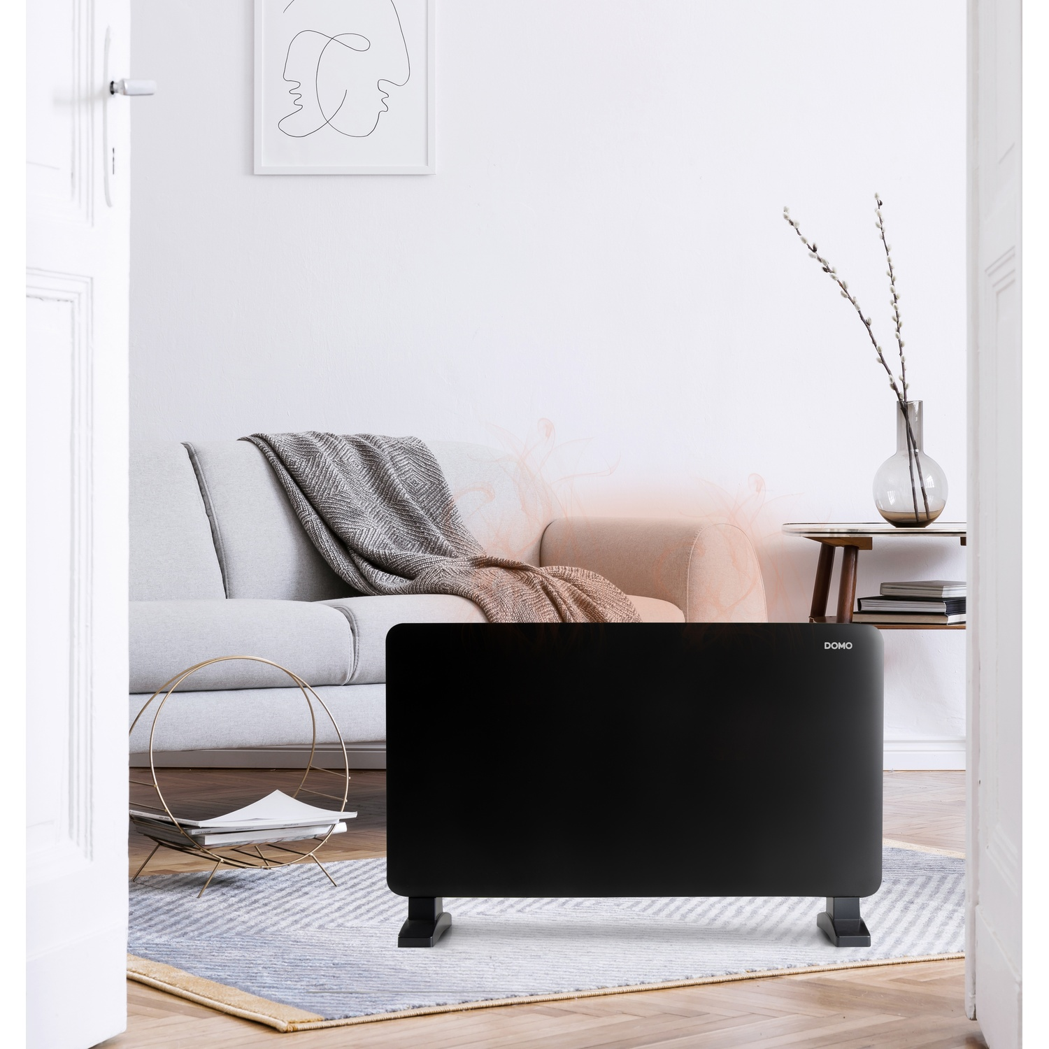 A black heater stands in the foreground of a living room with a sofa, rug, and side table.