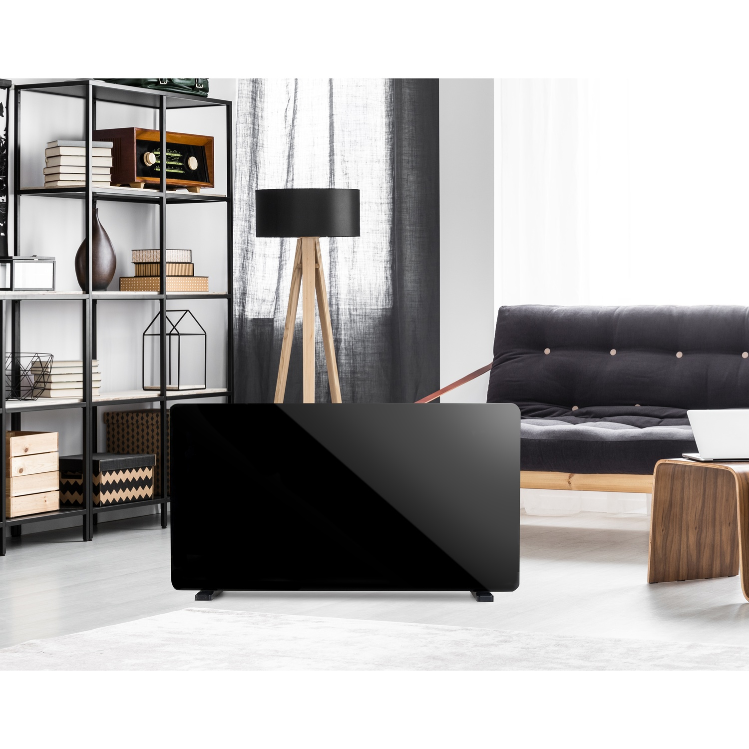 A black glass electric heater stands in a modern living room with a metal shelving unit, lamp, and sofa.