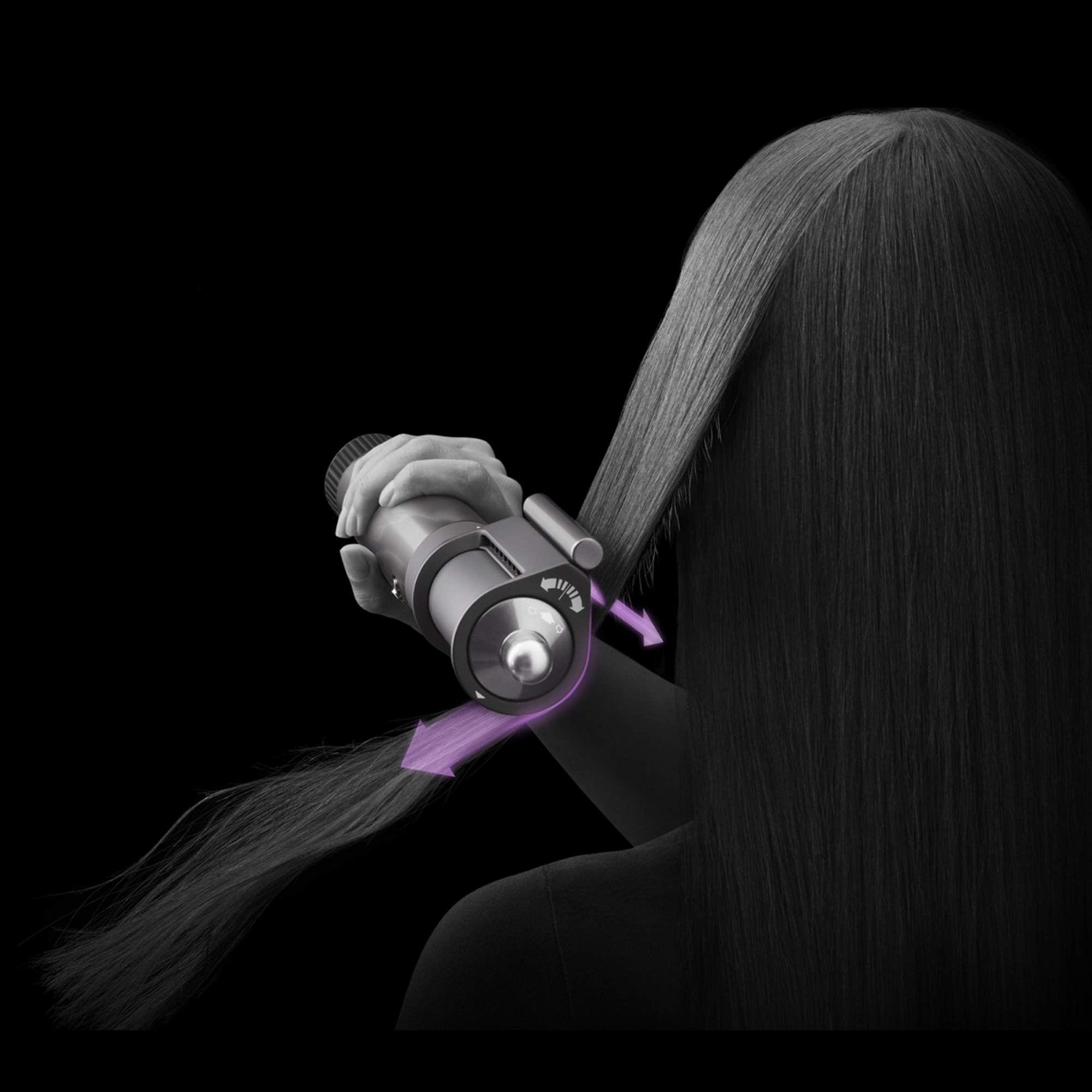 Una persona usa un moldeador de cabello en cabello oscuro sobre fondo negro con flechas púrpuras.