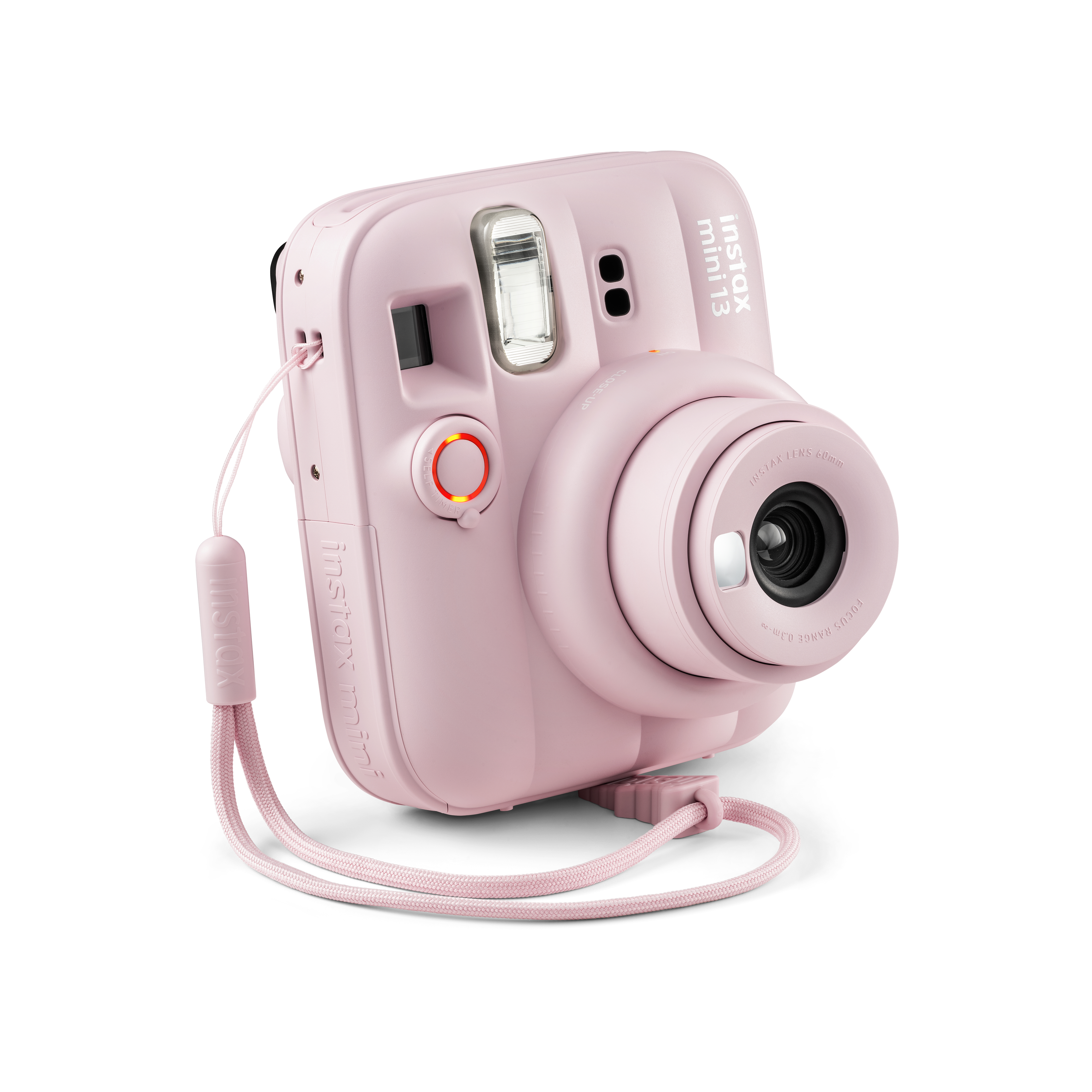 Eine pastellrosa Instax Mini Sofortbildkamera mit passender Handschlaufe auf weißem Hintergrund.