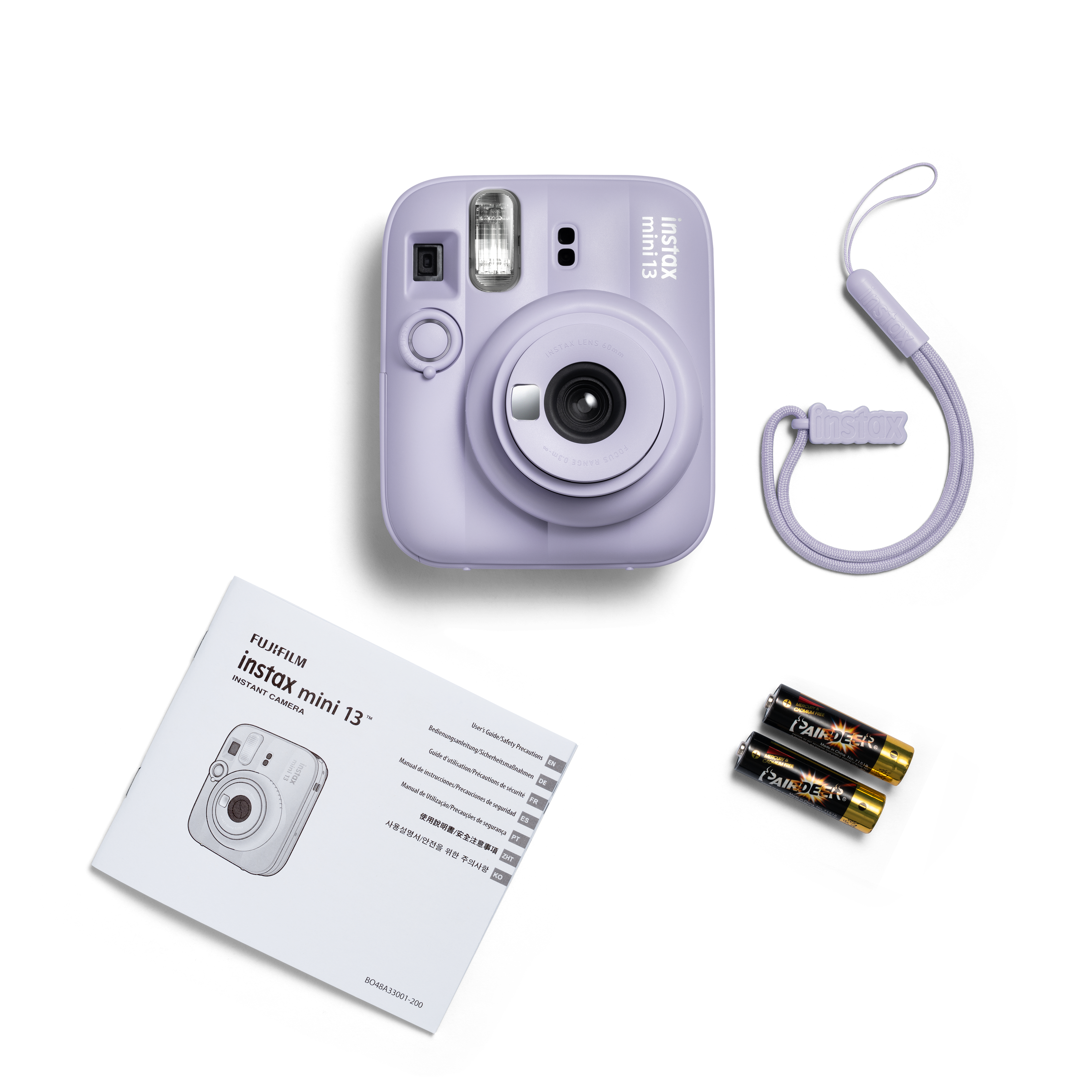 Lila Instax Mini 13 Sofortbildkamera mit Handgelenkschlaufe, Anleitung und zwei Batterien auf weißem Hintergrund.