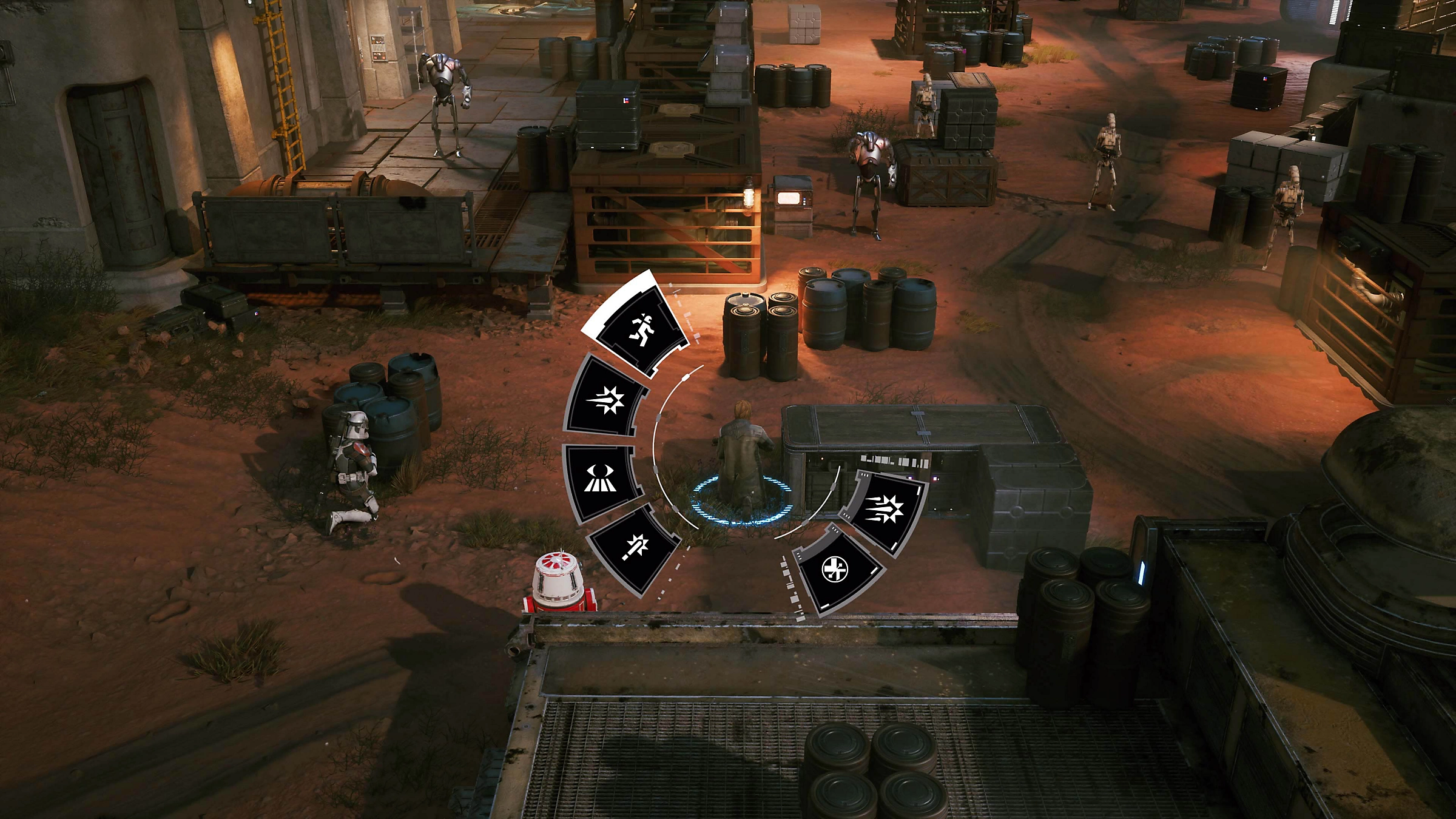 Scena di videogioco dall'alto con personaggi, menu radiale, barili ed edifici industriali.