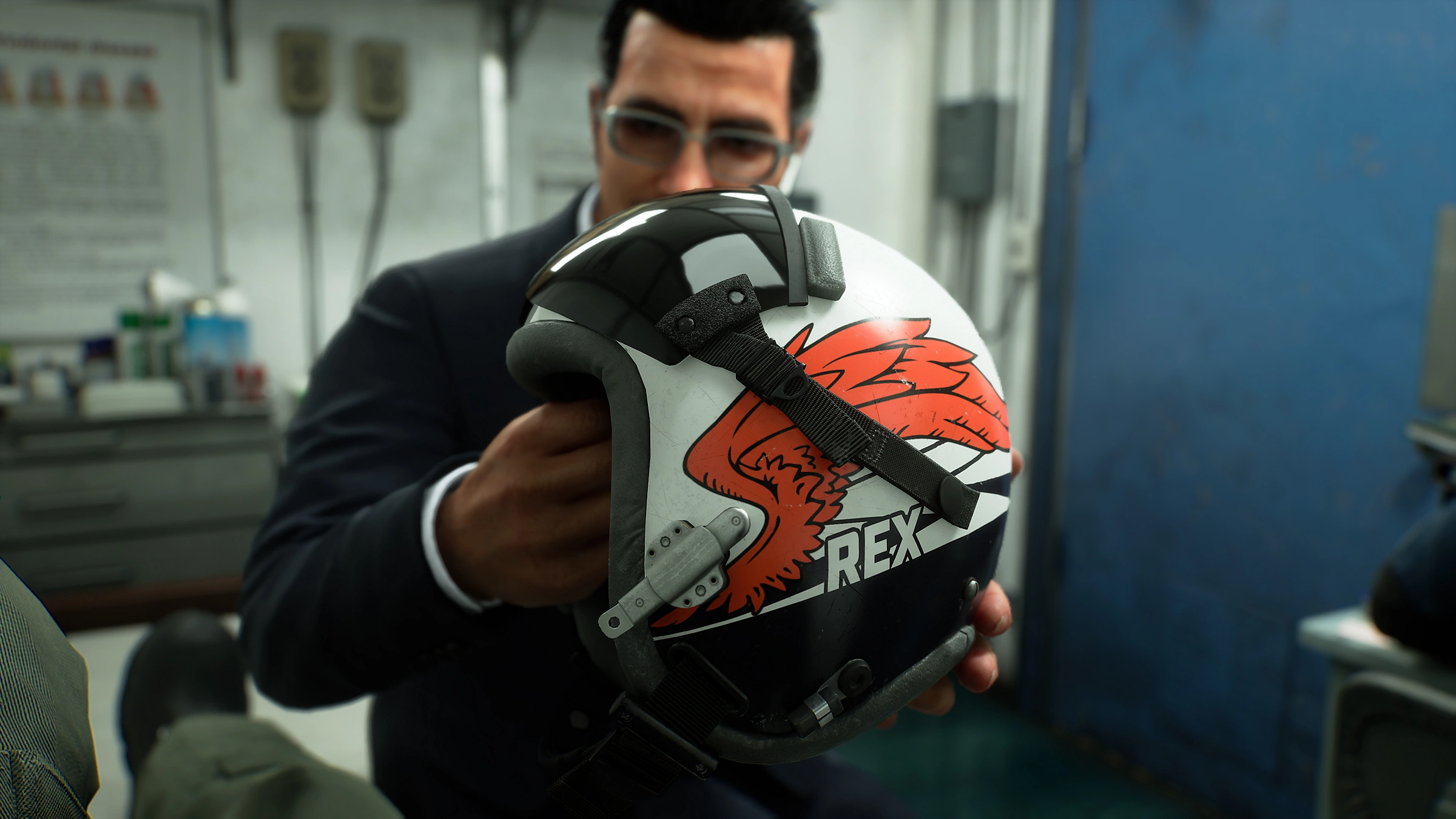 Un uomo in abito tiene un casco nero, bianco e rosso con un disegno ad ala rossa e la scritta REX.