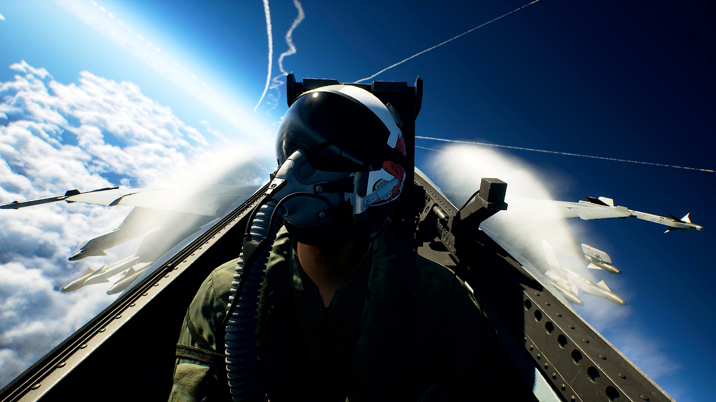 Un pilota con casco siede nella cabina di un jet sotto un cielo nuvoloso.
