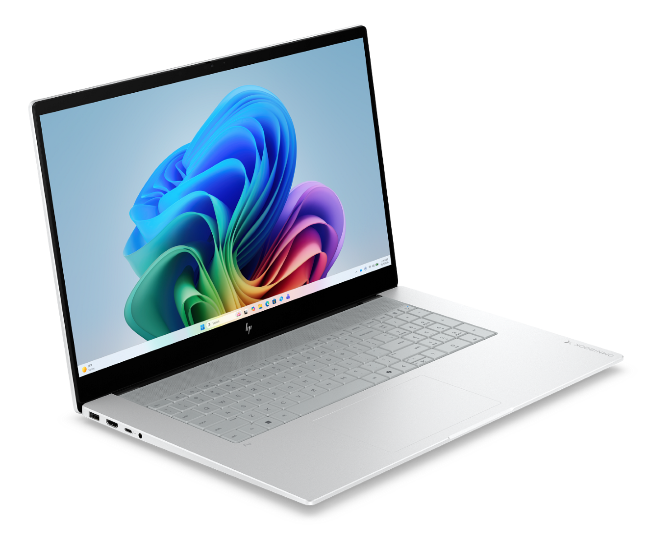 Srebrny laptop jest otwarty na czarnym tle, wyświetlając kolorową abstrakcyjną falistą tapetę na ekranie.