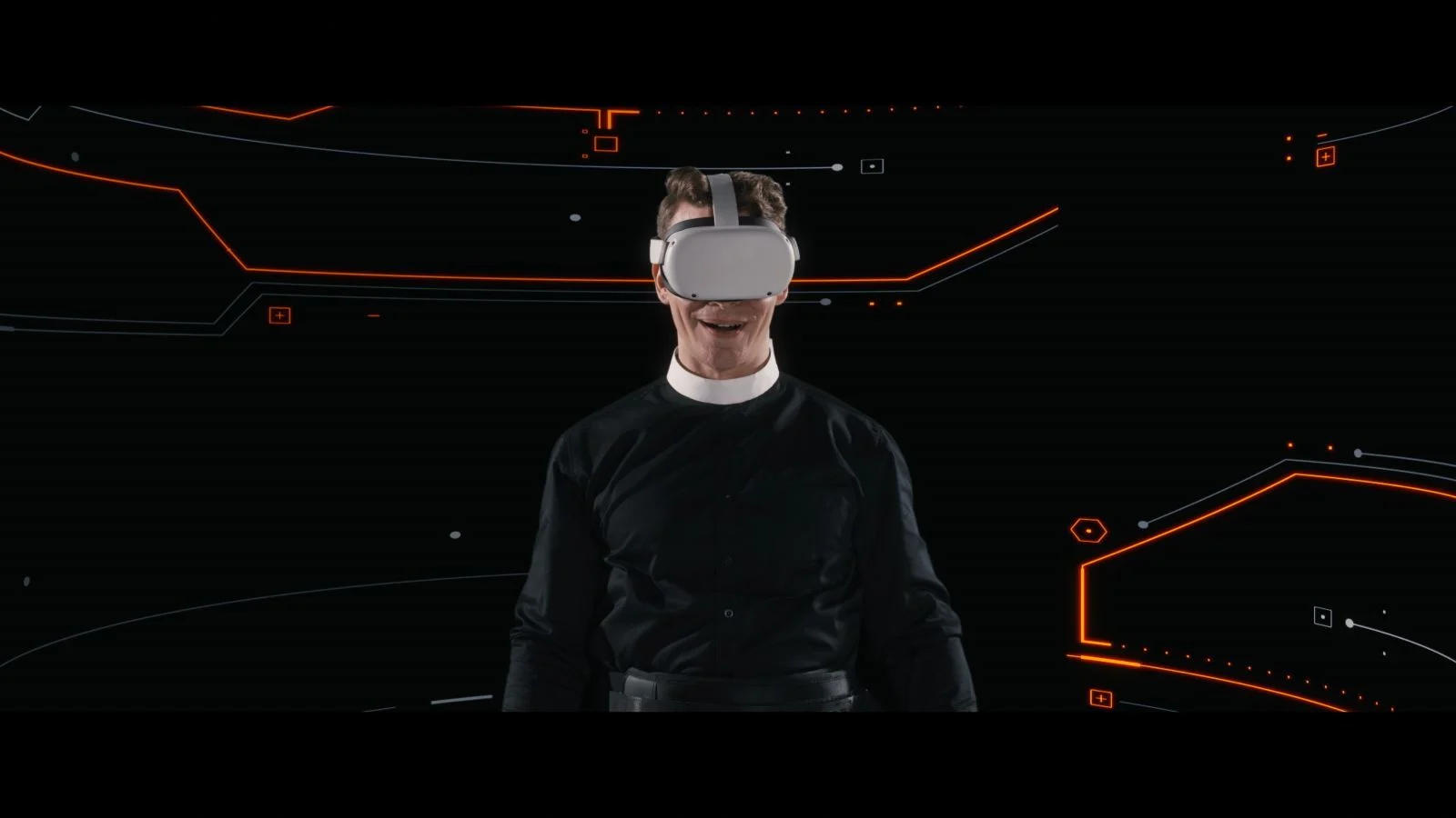 Ein Mann mit Klerikalkragen trägt vor dunklem Hintergrund mit orangefarbenen Grafiken ein VR-Headset.