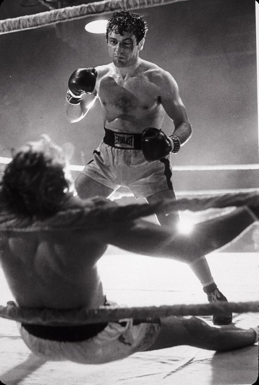 Ein Boxer steht im Ring und blickt auf seinen am Boden liegenden Gegner herab.