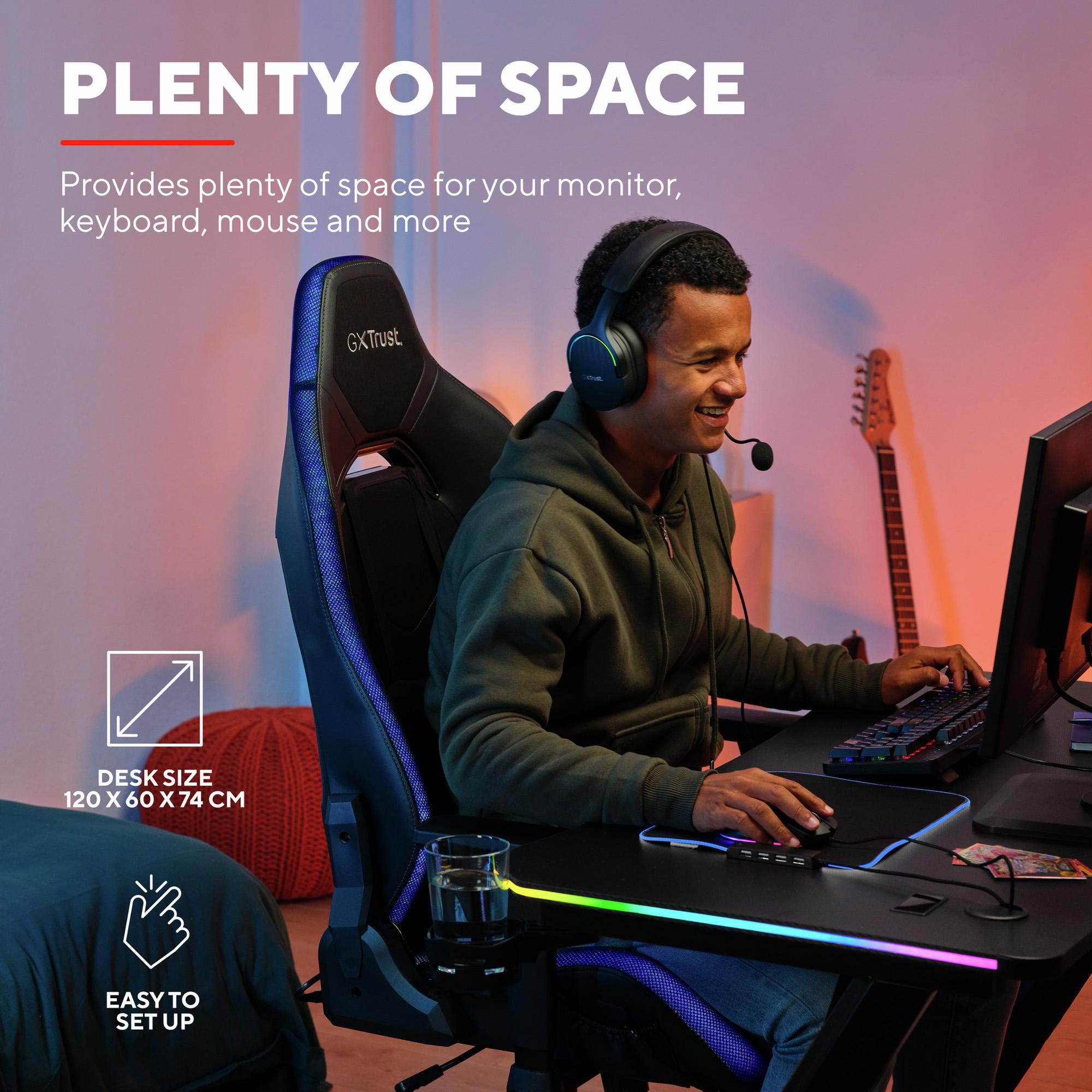 Ein junger Mann sitzt in einem Gaming-Stuhl und nutzt einen PC an einem Schreibtisch.