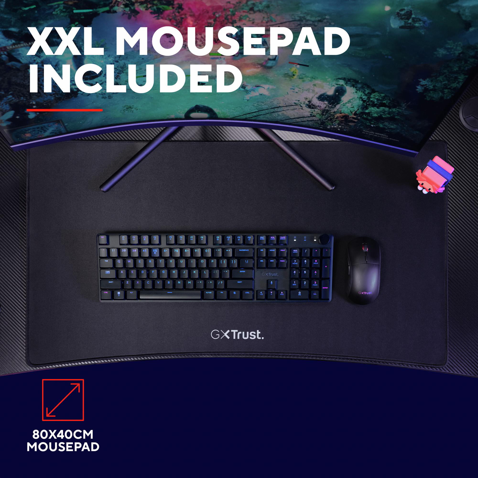 Top-Ansicht eines GXTrust XXL-Mauspads mit schwarzer Tastatur und Maus auf einem Schreibtisch unter einem Monitor.