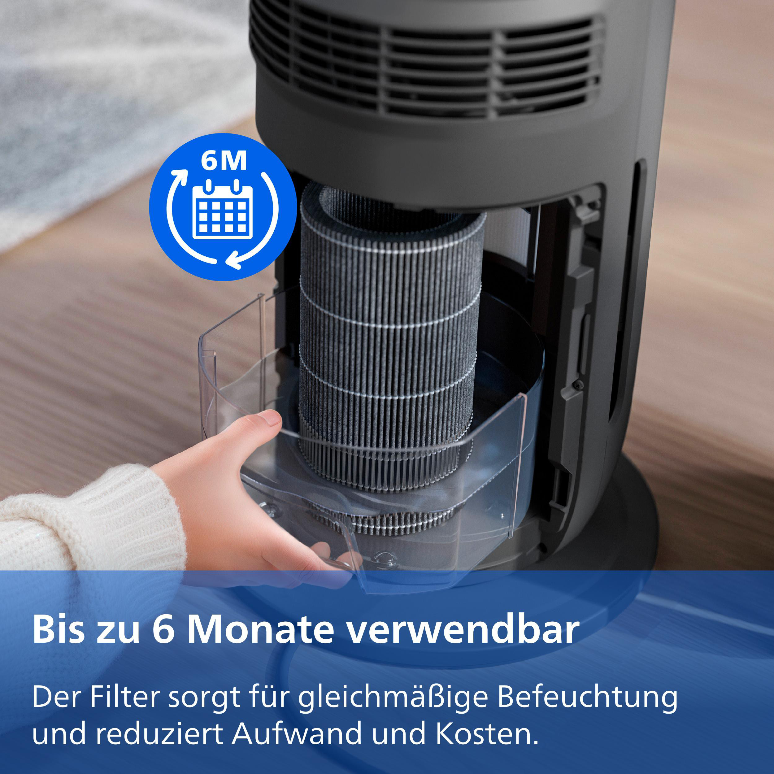 Eine Hand setzt einen zylindrischen Filter in einen grauen Luftbefeuchter ein.