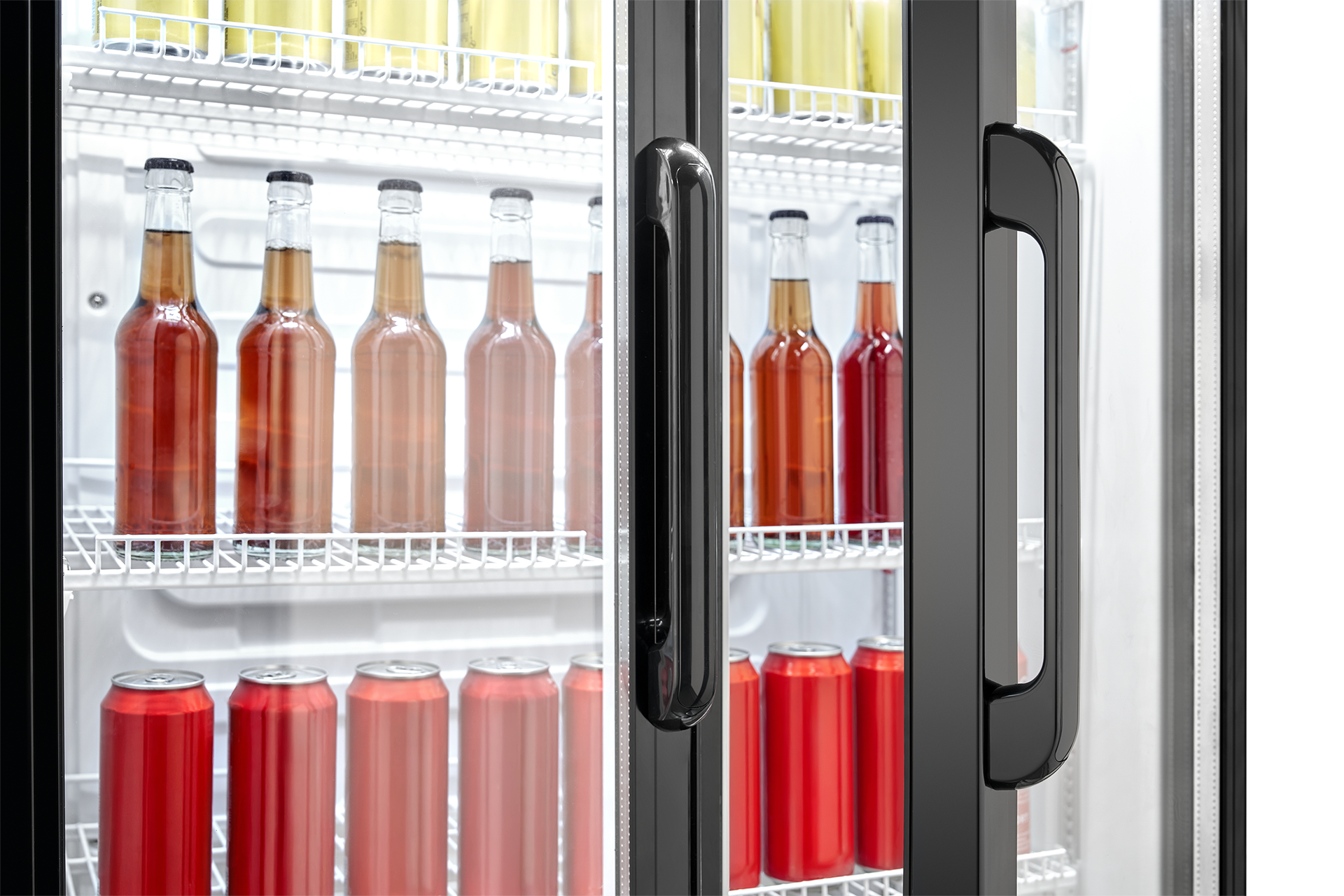 Ein beleuchteter Getränkekühlschrank mit Glasüren zeigt Reihen von Flaschen und roten Dosen.