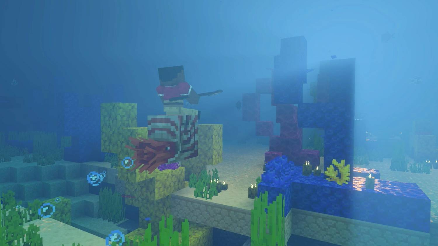 Escena submarina de Minecraft con arrecifes de coral, peces y agua azul.