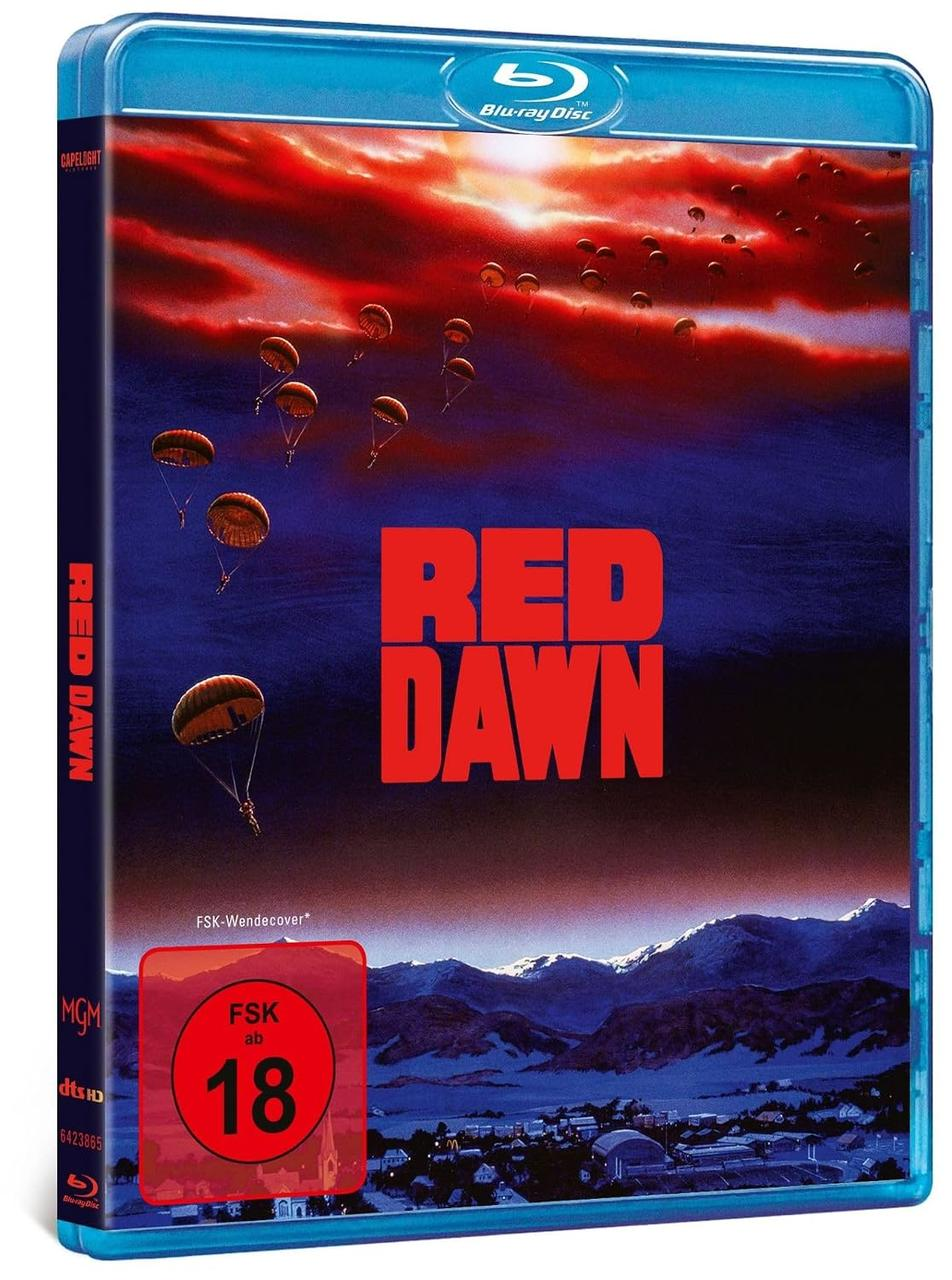 Blu-ray-Hülle von Red Dawn mit Fallschirmen im roten Abendhimmel über schneebedeckten Bergen und einer Stadt.
