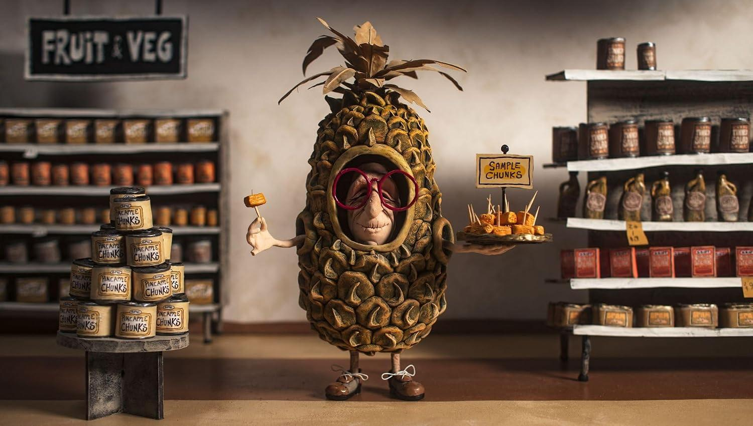 Eine Figur im Ananas-Kostüm hält in einem Lebensmittelgeschäft Probenstücke in den Händen.