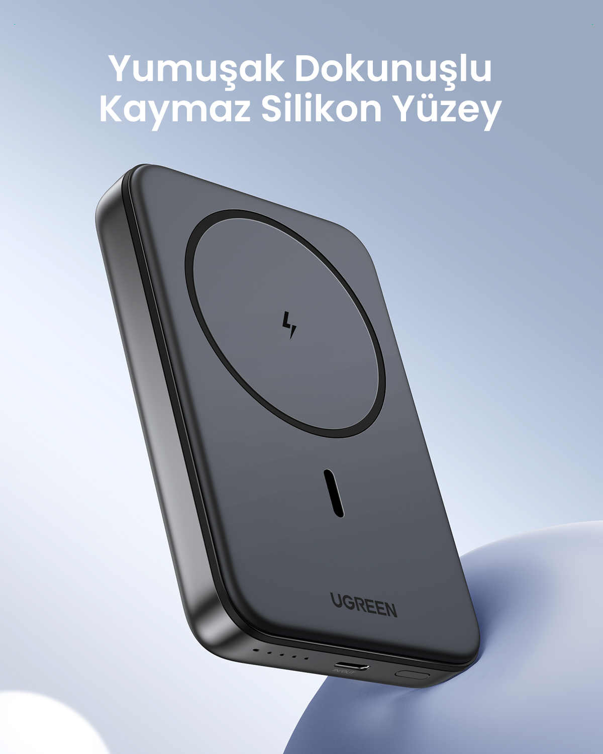 Yumuşak mavi arka planda manyetik şarj yüzeyine sahip gri UGREEN taşınabilir şarj cihazı.
