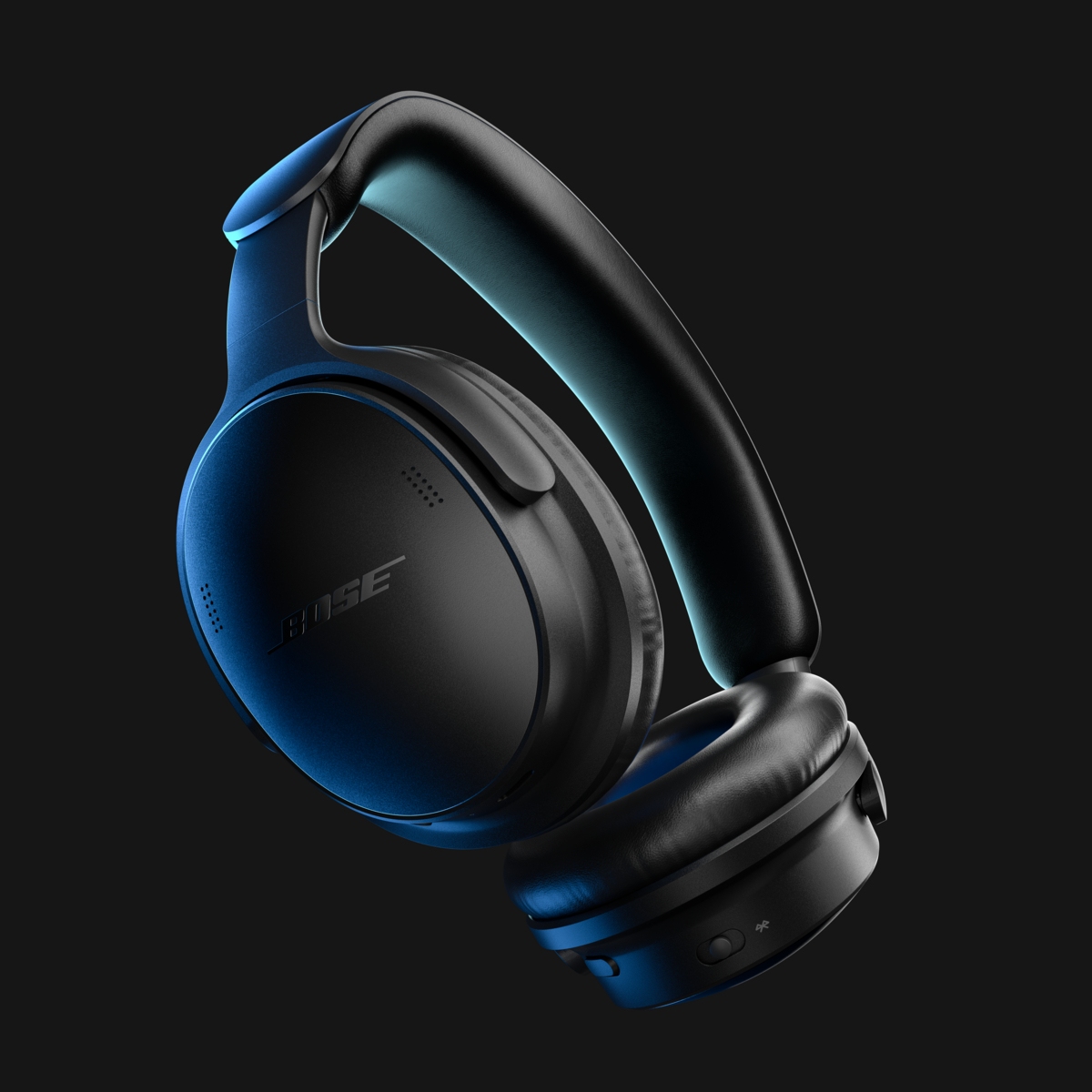Schwarze kabellose Bose-Over-Ear-Kopfhörer vor dunklem Hintergrund, beleuchtet mit blauem Licht.