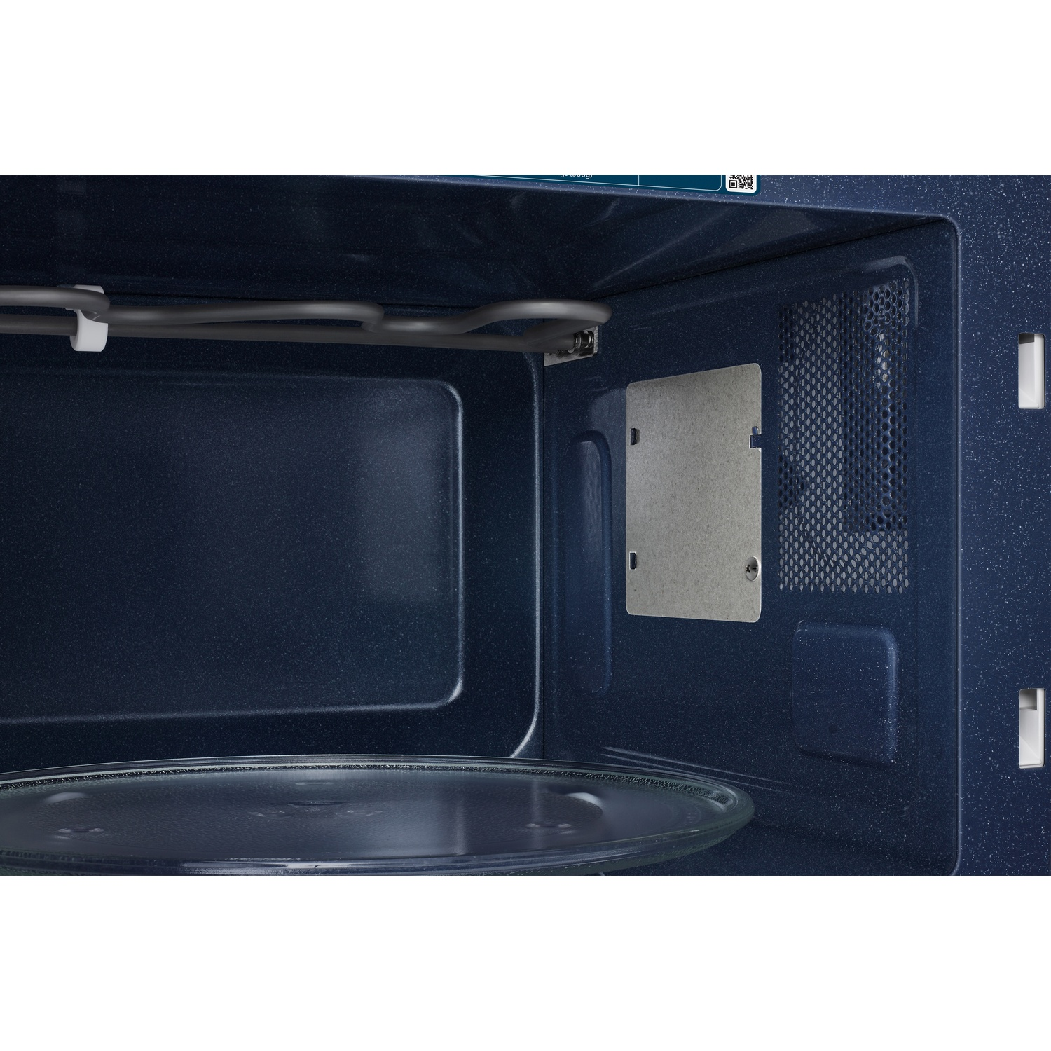 Interior of a blue microwave with a glass turntable and a top heating element.