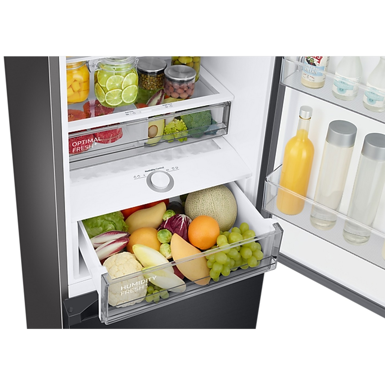 Intérieur de réfrigérateur ouvert avec des bocaux, des fruits et légumes frais dans les tiroirs et des bouteilles.