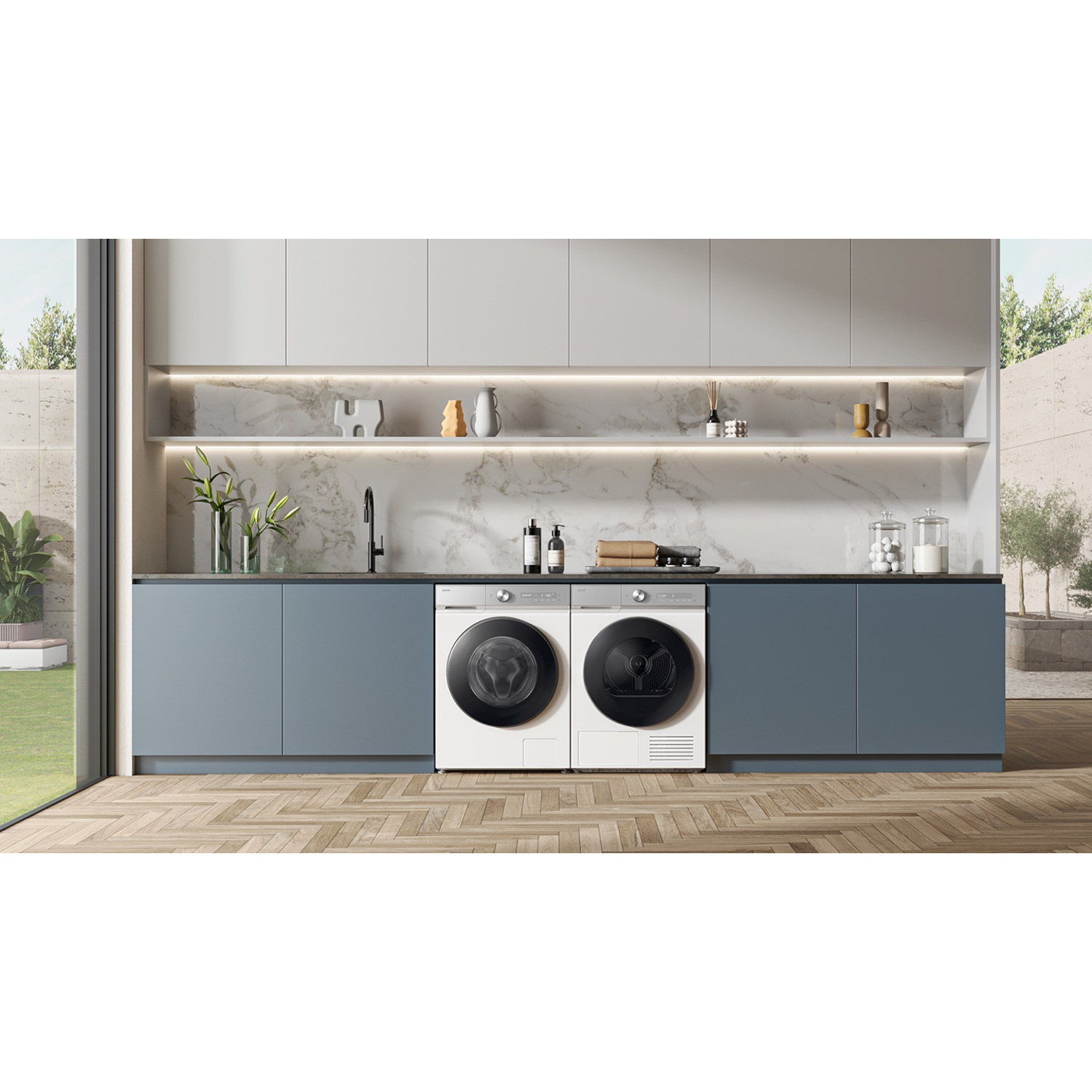 Modern laundry room featuring grey cabinets, marble backsplash, and two white appliances.
