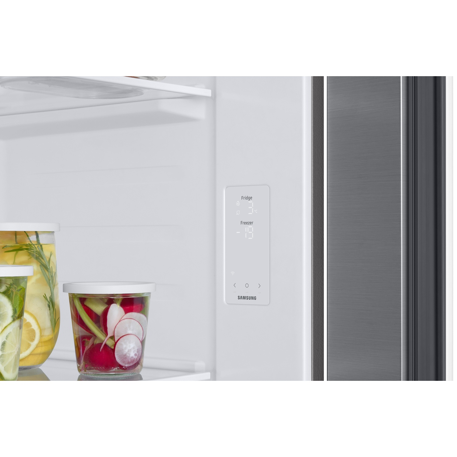 Interior of a Samsung refrigerator showing a digital temperature display, containers with vegetables and glass shelves.
