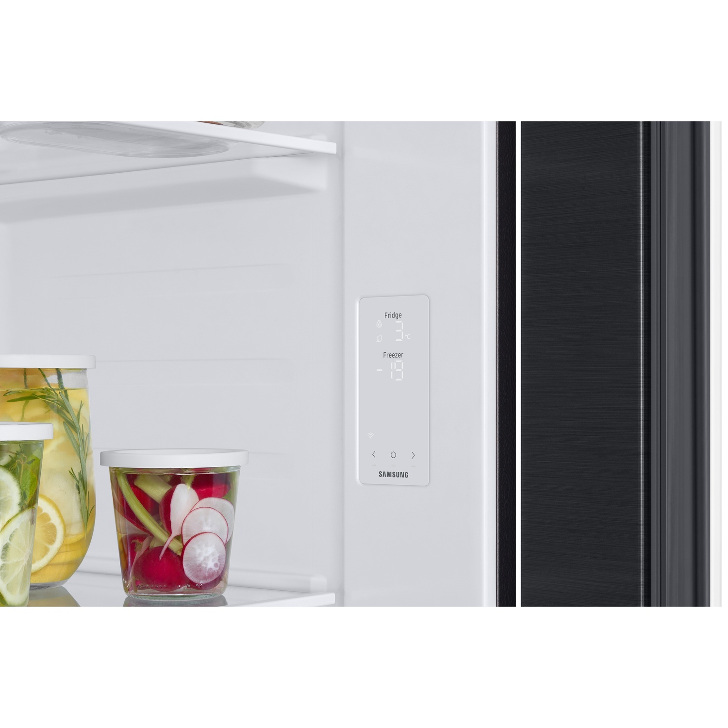 Interior of a refrigerator with digital display and jars of pickled vegetables on a shelf.