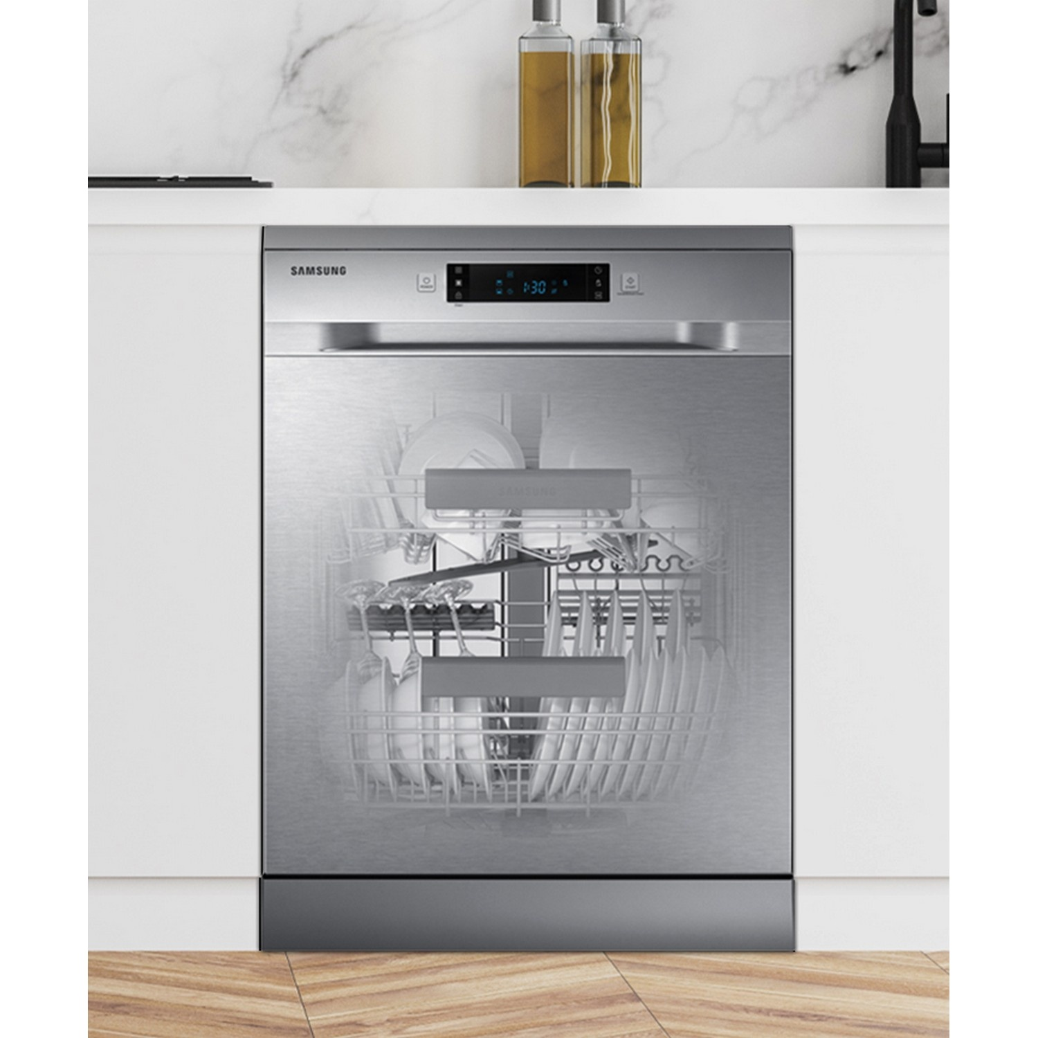 A silver Samsung dishwasher is built into a white kitchen counter, showing dishes inside.