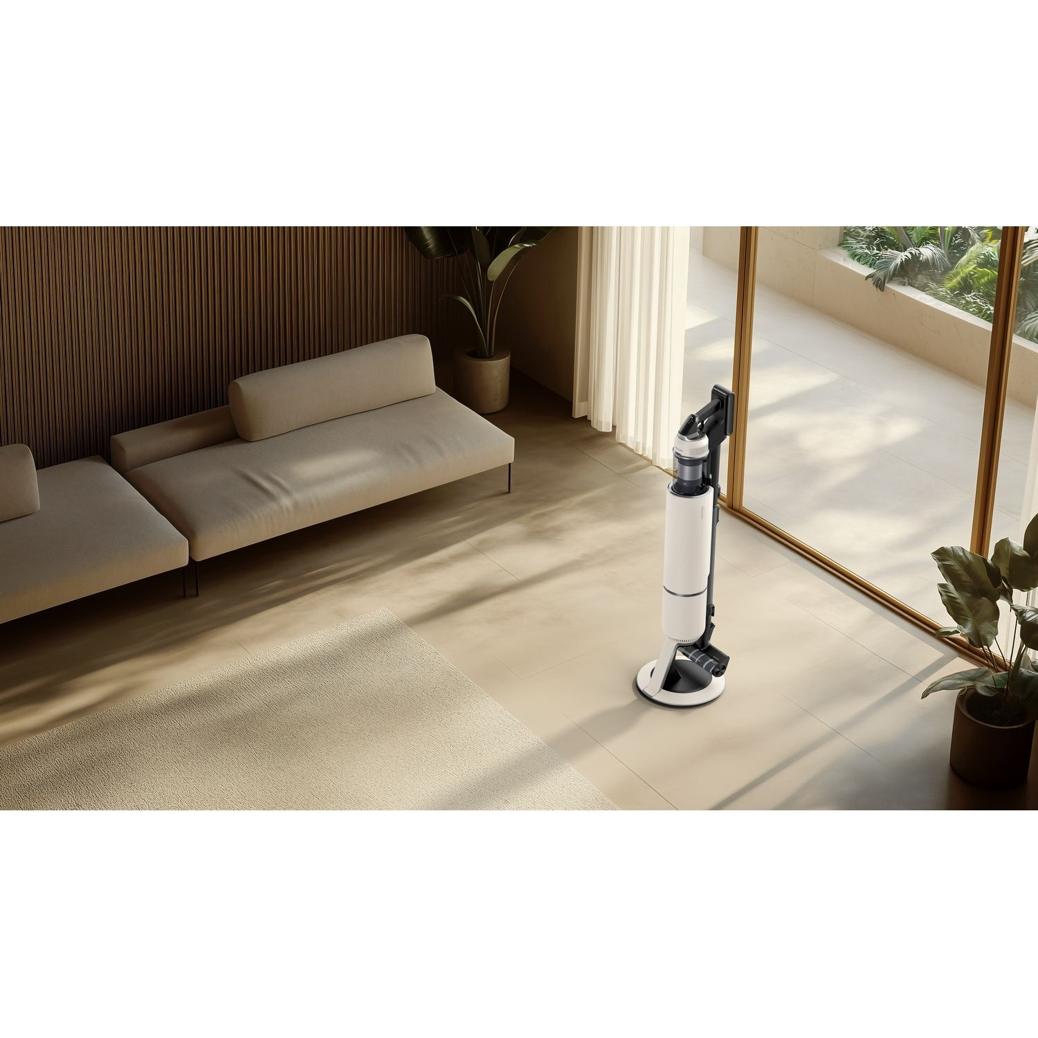 Un aspirateur balai blanc et noir sur sa station de charge dans un salon moderne et lumineux près d'un canapé.