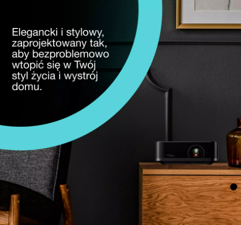 Czarny projektor stoi na drewnianej szafce na tle ciemnej ściany, z polskim tekstem na turkusowej grafice.